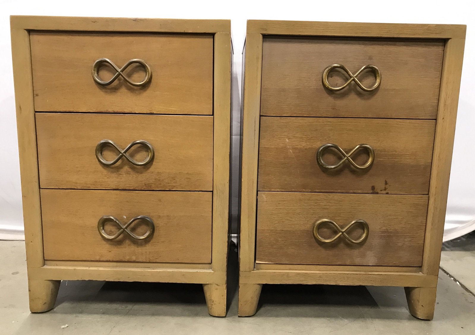 Pair Vintage Carved Wooden Nightstands: Nightstands are vintage and wooden. Each have gold toned brass infinity symbol style handles. Drawers have hand dovetailing. Each nightstand has 3 drawers. Nightstands, side tables, vintage nightstand