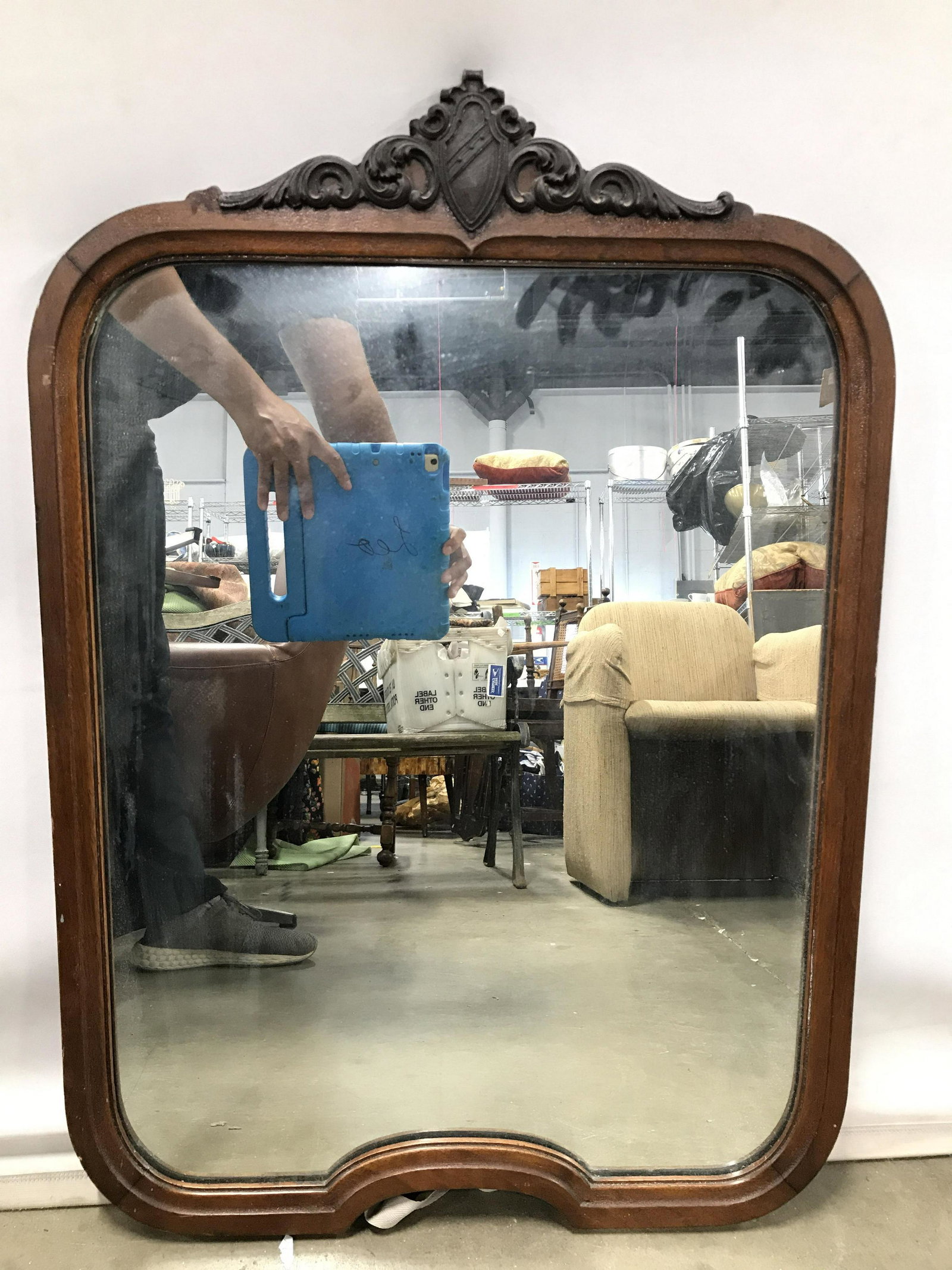 Vintage SH GRAHAM CO Mirror: Backside of piece has tag which reads SH GRAHAM. Mirror has carved wooden frame. Possibly hand crafted. Top of piece has carved coat of arms and c scroll detail. Piece measures approximately 32 inches