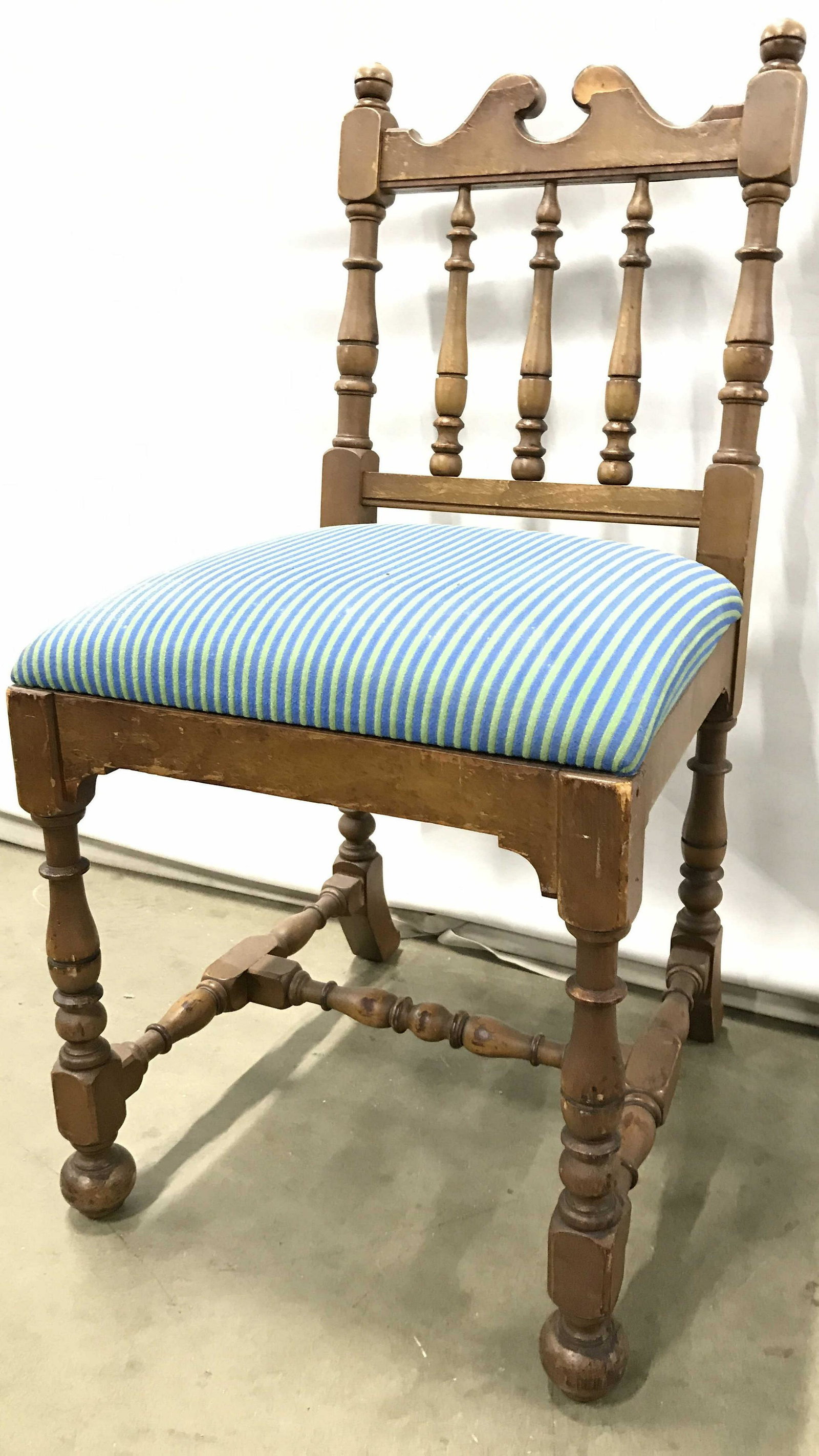 Vintage Carved Wooden Children’s Chair: Children’s chair is vintage and wooden. Piece is vintage possibly antique, Piece is possibly hand crafted. Piece has blue toned striped detailed seat cushion upholstery. Vintage chair, chair, childr