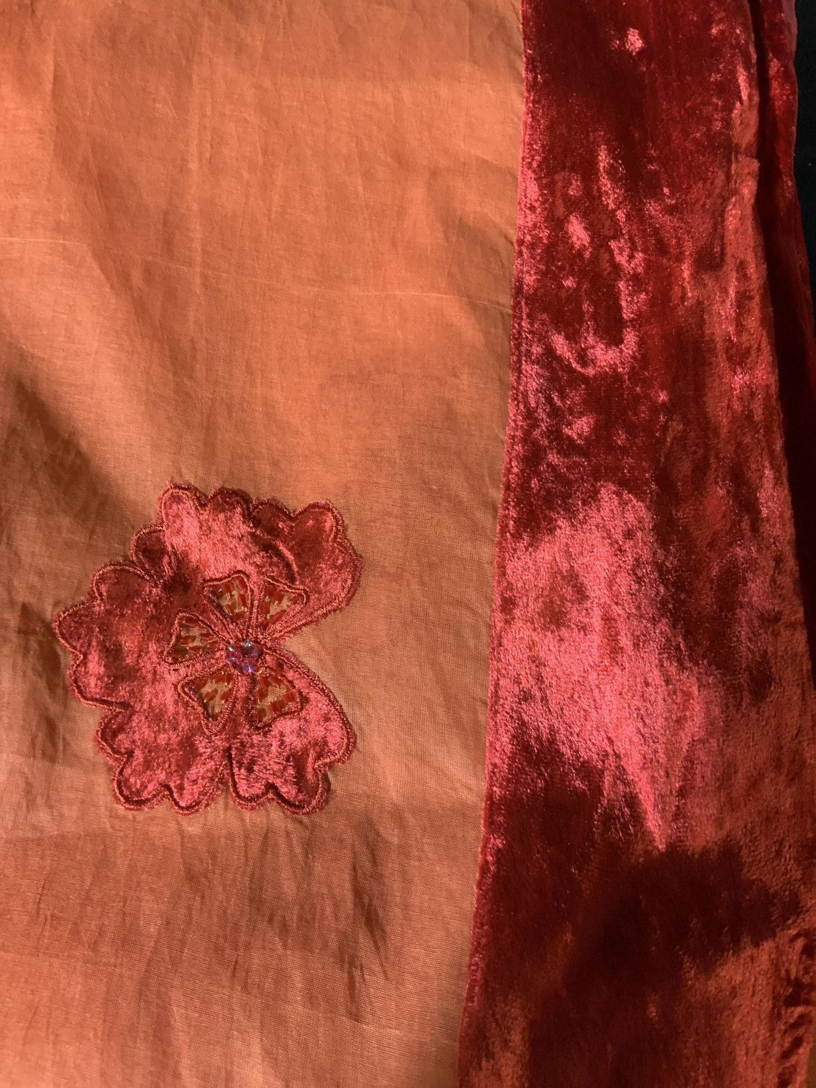 New Still in Packaging Set of 2 Tablecloths: large table cloths in orange with a red felted velvet floral pattern and beading around the edge of where it hangs over the side, made of composite fabrics, this table cloth comes with its own sheer f