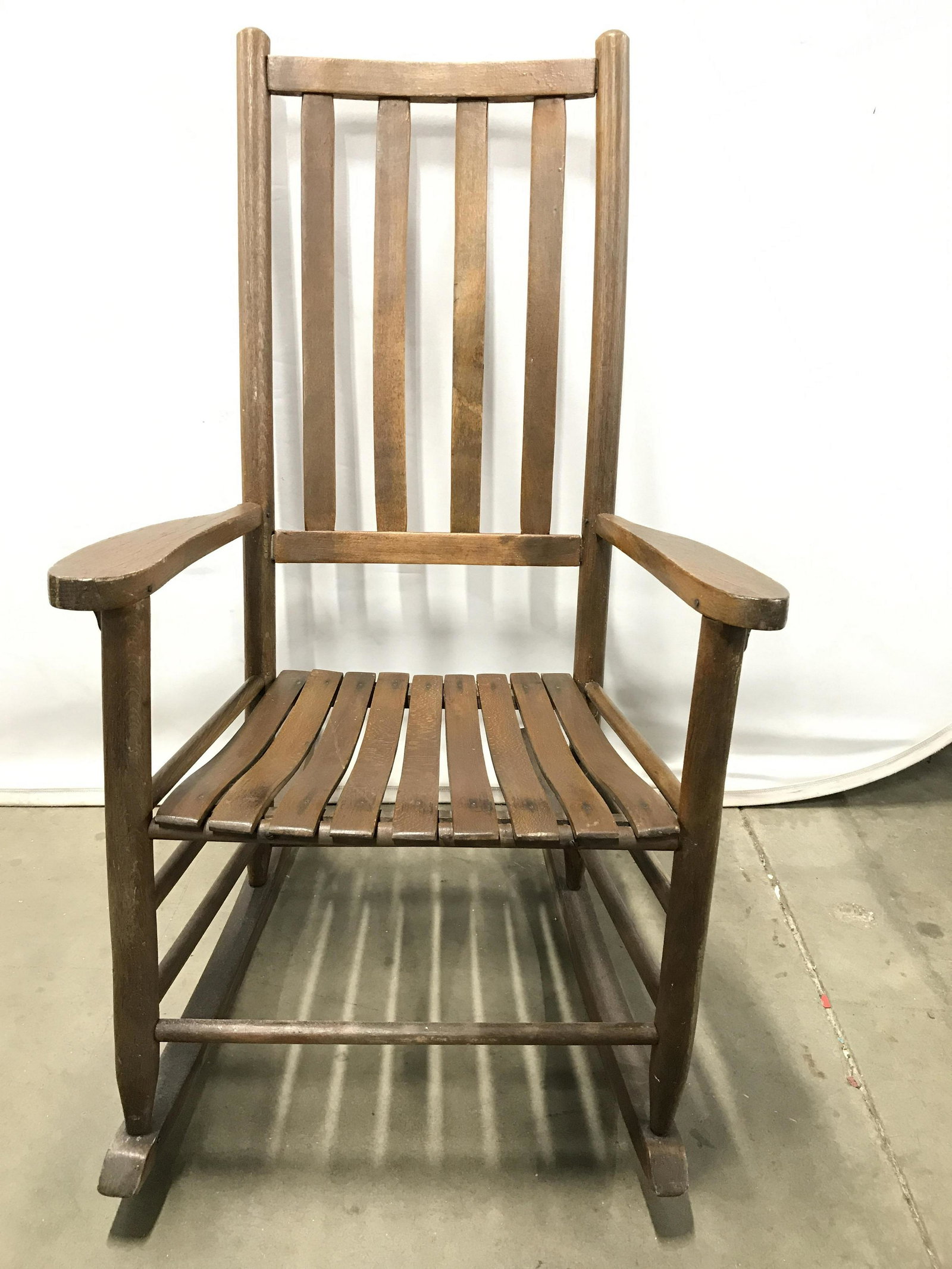Vintage Carved Wooden Rocking Chair: Rocker chair is wooden and brown toned. Piece is vintage. Chair is possibly teak. Rocking chair, wooden rocking chair, porch chair, wooden chair, wooden rocking chair, vintage rocking chair. Piece mea