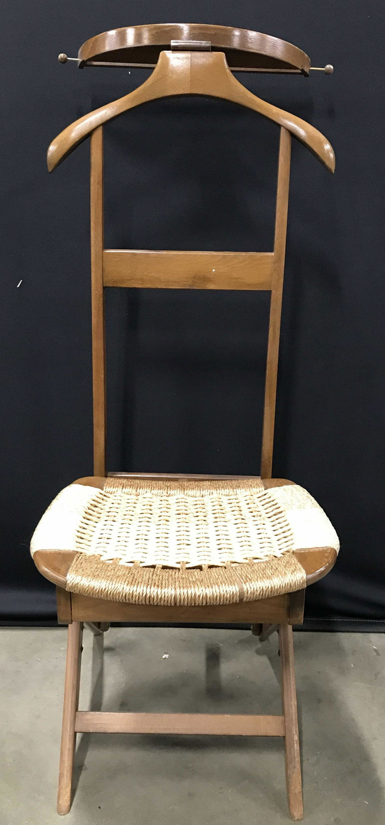 Carved Wooden Valet Stand Storage Chair: Valet is wooden. Piece has woven rope seat. Seat flips open to reveal storage area. Valet stand appears to possibly be vintage. Piece measures approximately 46 inches tall 19 inches wide 25 inches dee