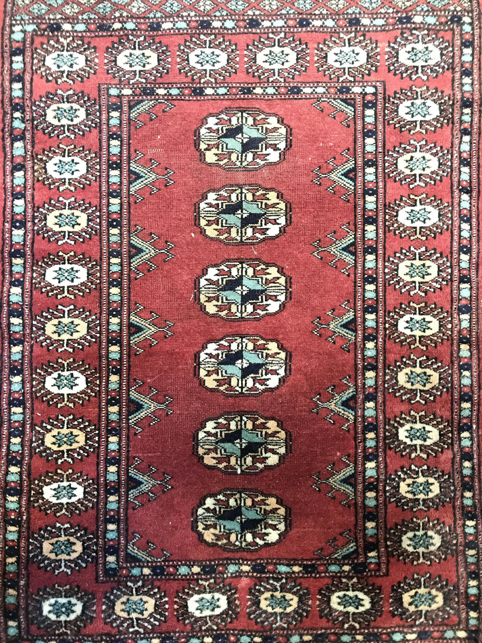 Vintage Handmade Bokhara Prayer Size Rug: Rug is handmade and wool. Piece is vintage. Rug contains multi toned geometric detail. Rug, carpet, area rug, wool rug, handmade rug, vintage rug, Bokhara rug, petite rug, prayer size rug. Piece measu