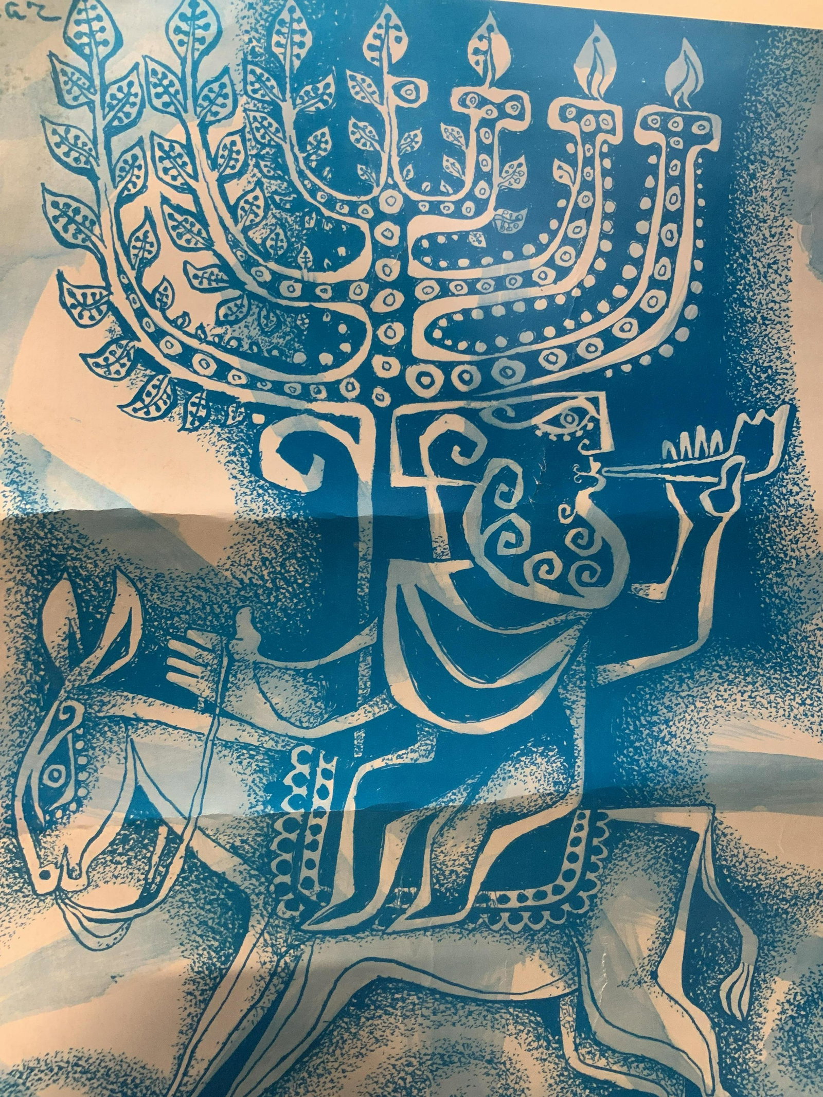 P. Shaaz Vintage Hanukkah Poster: P. Shaaz Vintage September 1974 Hanukkah poster, depicting a man riding a donkey playing the shofar, behind and above the man is a menorah one side with lit candles the other side growing into tree br