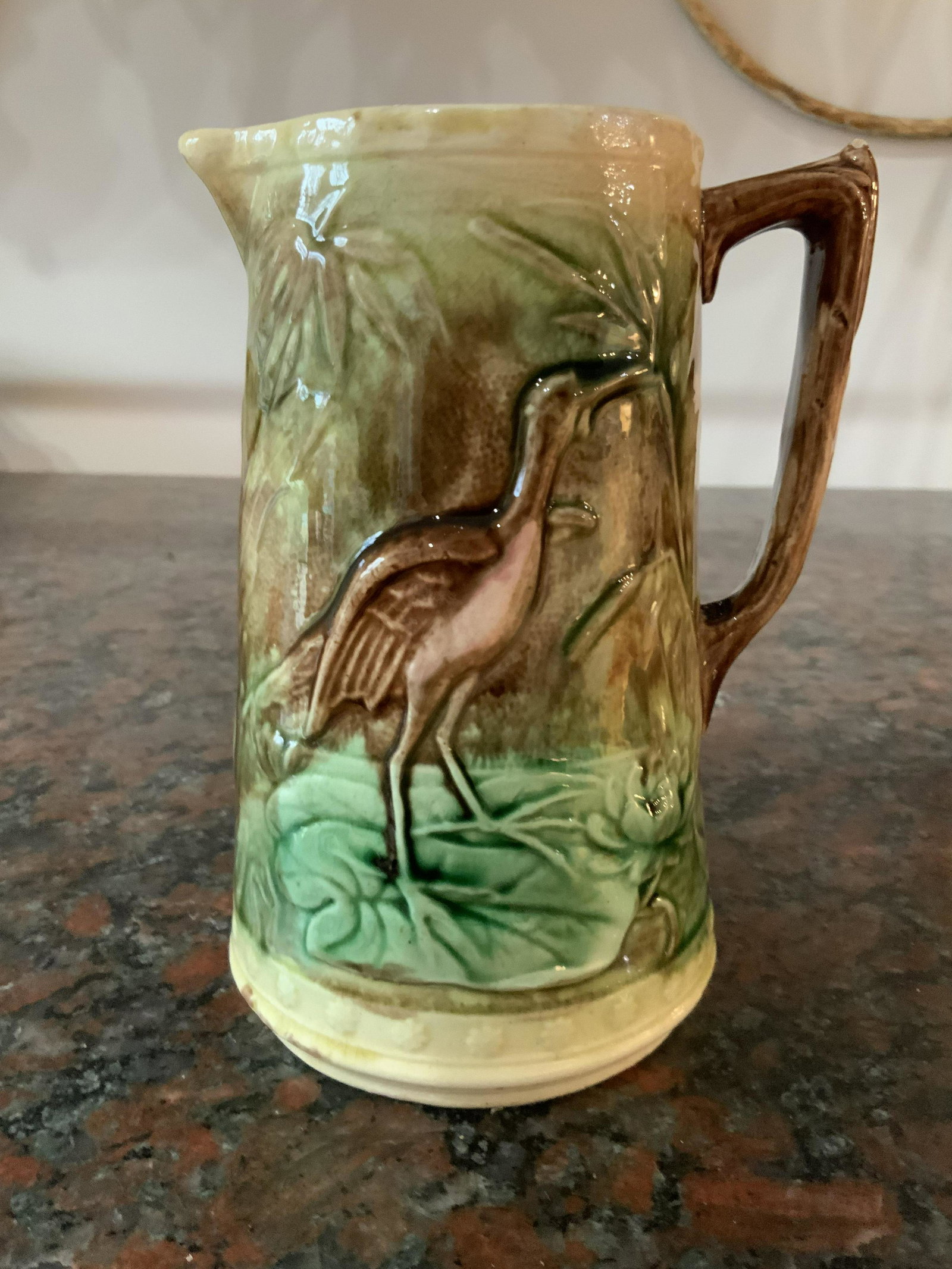 Antique Majolica Pitcher Crane Figural: Brightly glazed majolica pottery ceramics collectible antique Majolica with detail of crane in marsh setting, pink in side, chip near handle, wear to glaze,pitcher, vase, vessel, measures ht 6.5 inche