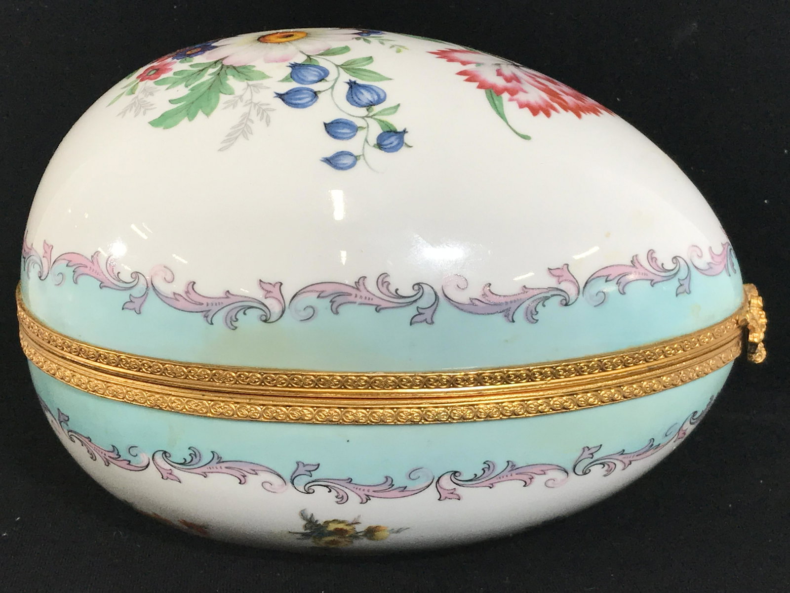 Vintage Porcelain Egg Keepsake Box: Underside has illegible marking. Piece has intricate floral, leaf and ornate detail. Piece is vintage. Measures approximately 7 inches long 5 inches wide and tall. Porcelain egg, keepsake box, trinket