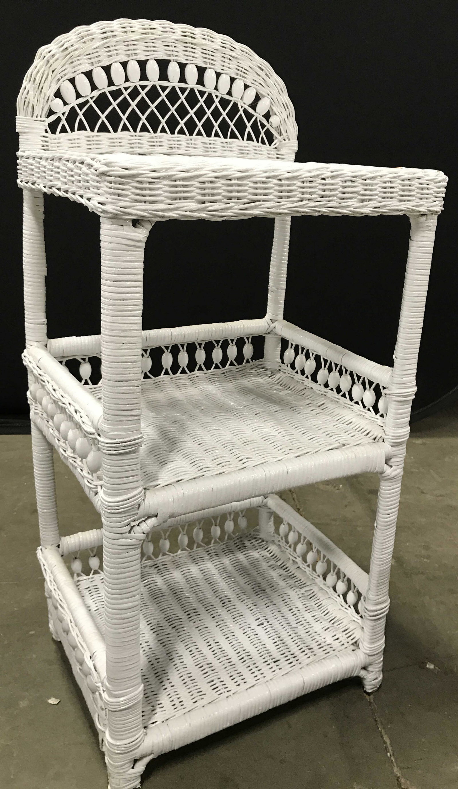 Vintage White Toned Wicker Wash Stand: Piece is white toned and wicker. Stand is vintage. Wash stand, side table, end table, wicker wash stand, wicker side table. Side table contains 1 shelf in center & bottom area. Center and lower area h