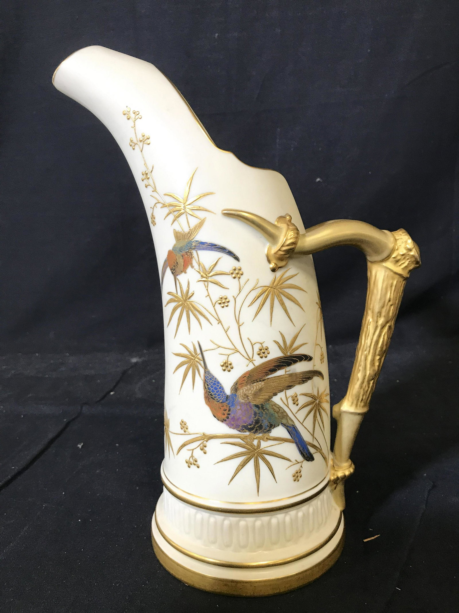 Vintage ROYAL WORCESTER Staghorn Handle Pitcher: Underside of piece has ROYAL WORCESTER trademark. Piece has gold toned staghorn shaped handle. Pitcher is porcelain. Contains multi tone floral and hummingbird detail. Porcelain pitcher, royal Worcest