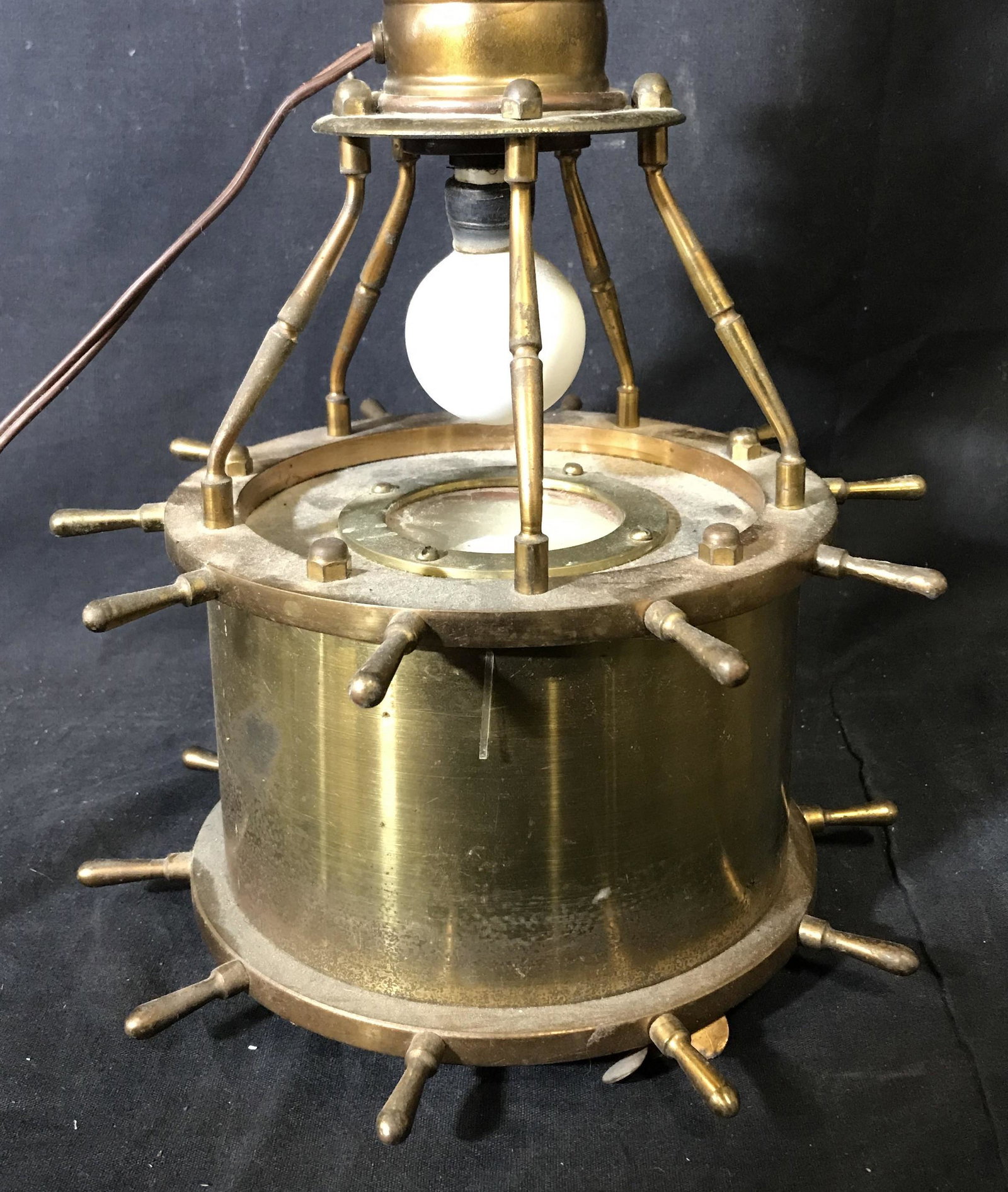 Vintage Nautical Wheel Form Lamp: Nautical themed lamp, a compass is built into the base, two boats wheel forms are built into the base, the finial resembles a propeller. Wear is consistent with age and use, bulb above compass require