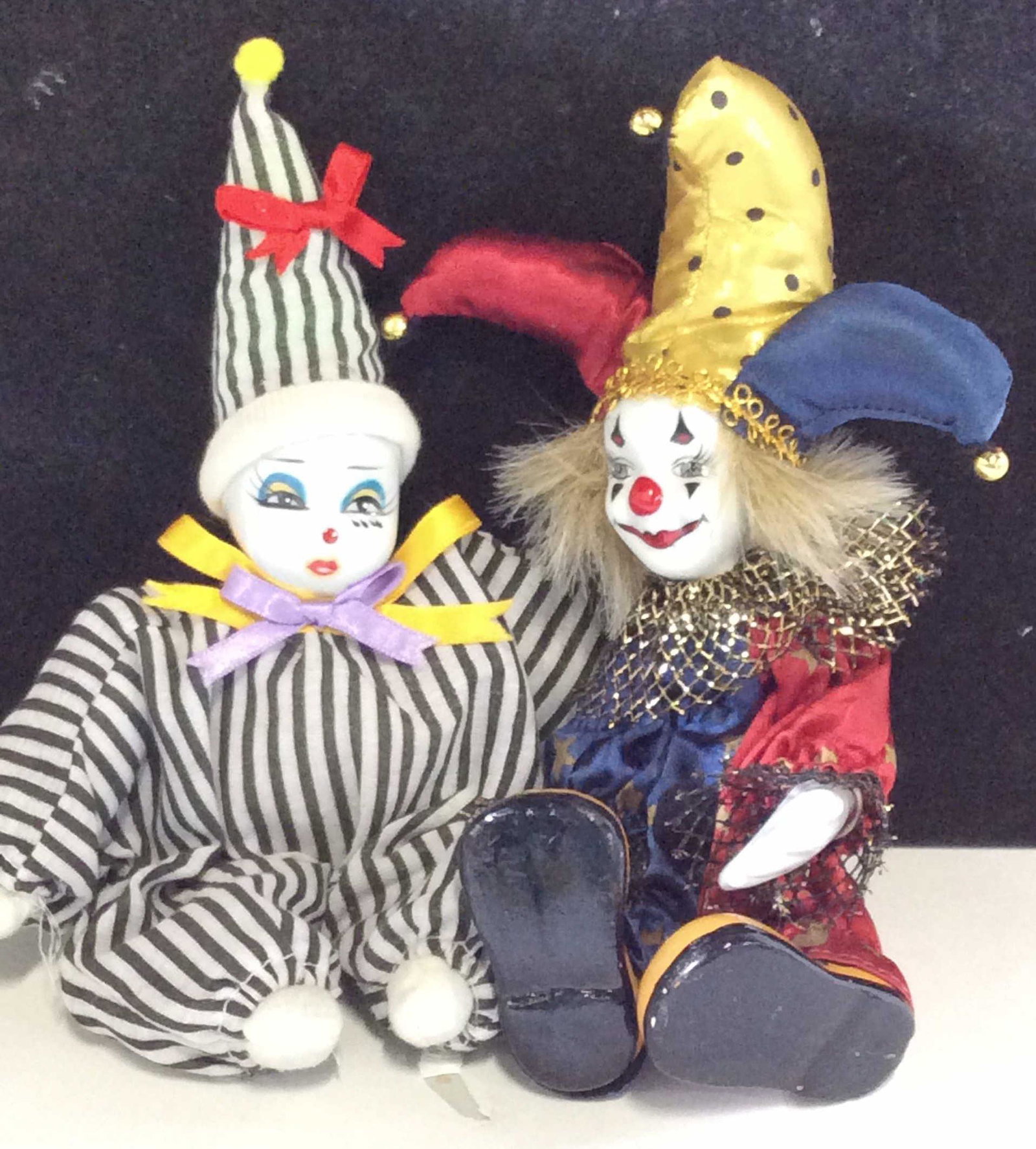 Lot 2 Porcelain Clown / Jester Dolls: Court Jester Clown, GOLD DEER & Co, LTD. Hand painted face, porcelain hands, face , painted composite shoes, 8.5 in Ht. Female Clown with pointed hat, stripe outfit, painted porcelain face. 9.5 in ht.