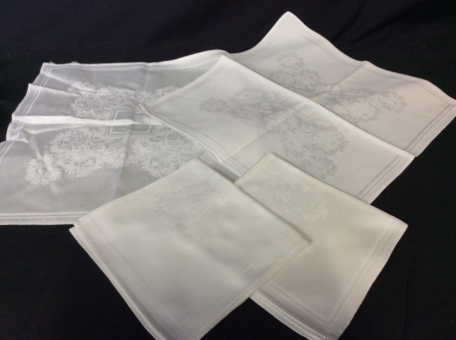 Lot White Rayon/Cotton Dinner Napkins: A few sets of similar patterns. Set 4 Silver threaded thick border square , reversible 17.5 x 18 in. Set 6 16.5 x 17.5 in Famille Rose and scroll border. Set 8 larger 21 x 21 in with light silver thre