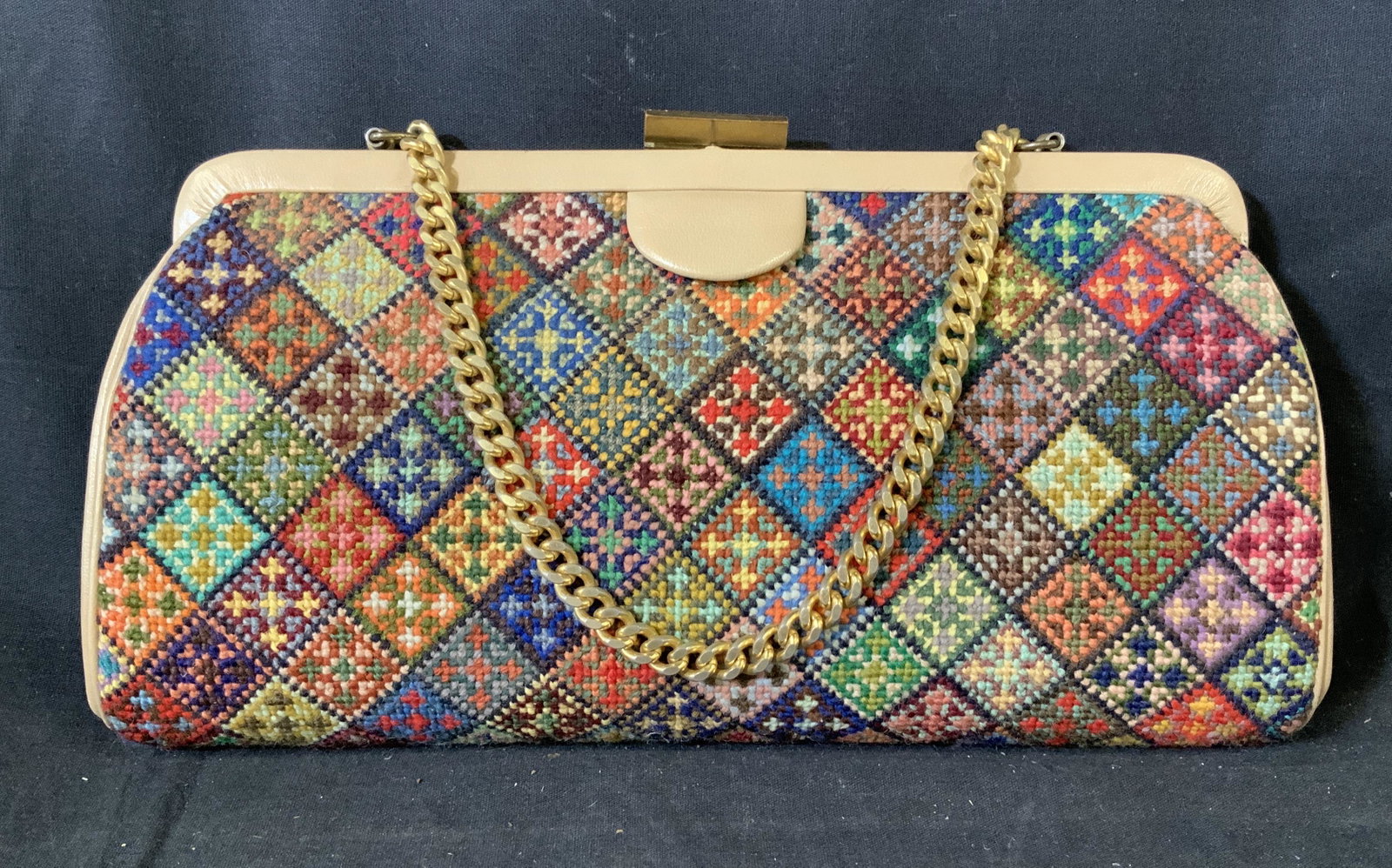 Vintage Needlepoint Hand bag: Vintage shoulder purse with needlepoint /cross stitched detailing and gold toned curb chain handle, gold toned clasp, three pockets within cream colored interior with a zipper, measures 6 3/8 inches x