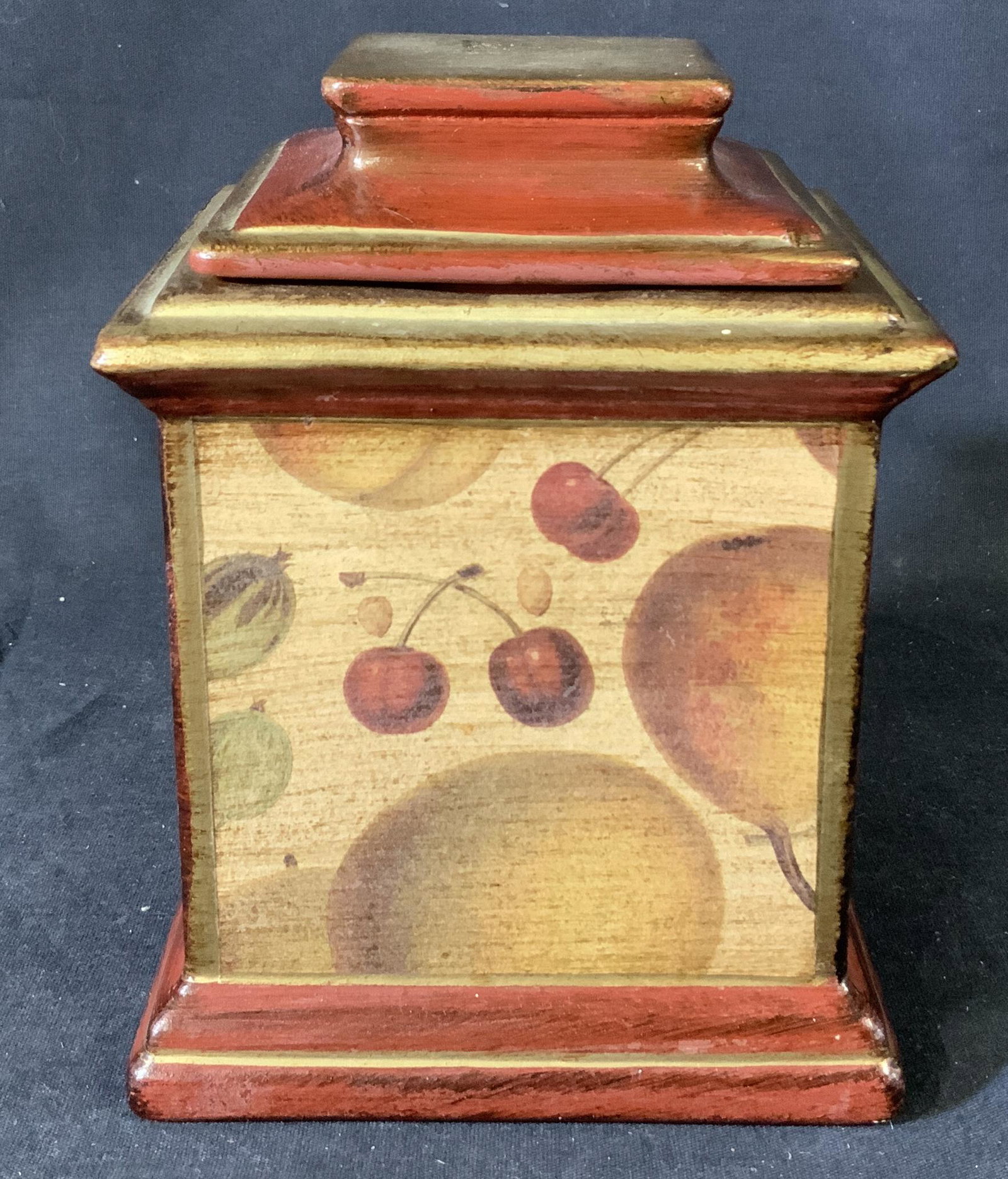 Italian Porcelain Decorative Lidded Box: Italian porcelain decorative box with removable lid, painted red and gold, features painted array of fruits and grain motifs, Sticker at base reads ‘Made in Italy’, Measures 6 3/8 inches x 4 7/8 i