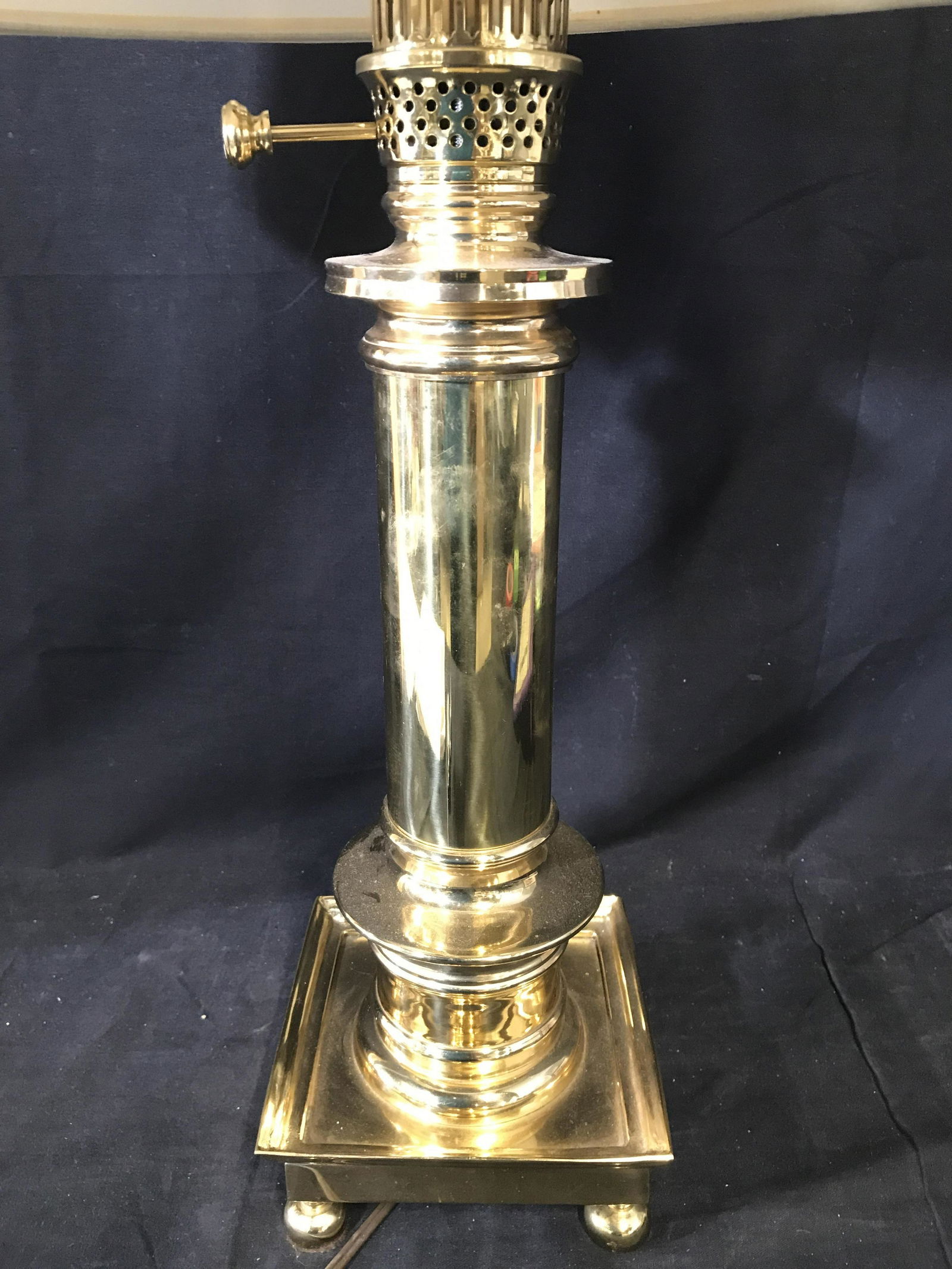 Brass Toned Table Lamp: Lamp is brass toned metal. Piece has 4 feet. Lamps includes cream toned shade. Piece has 2 spherical shaped pull switches. Piece measures approximately 28 inches tall 6 inches wide without shade. Lamp