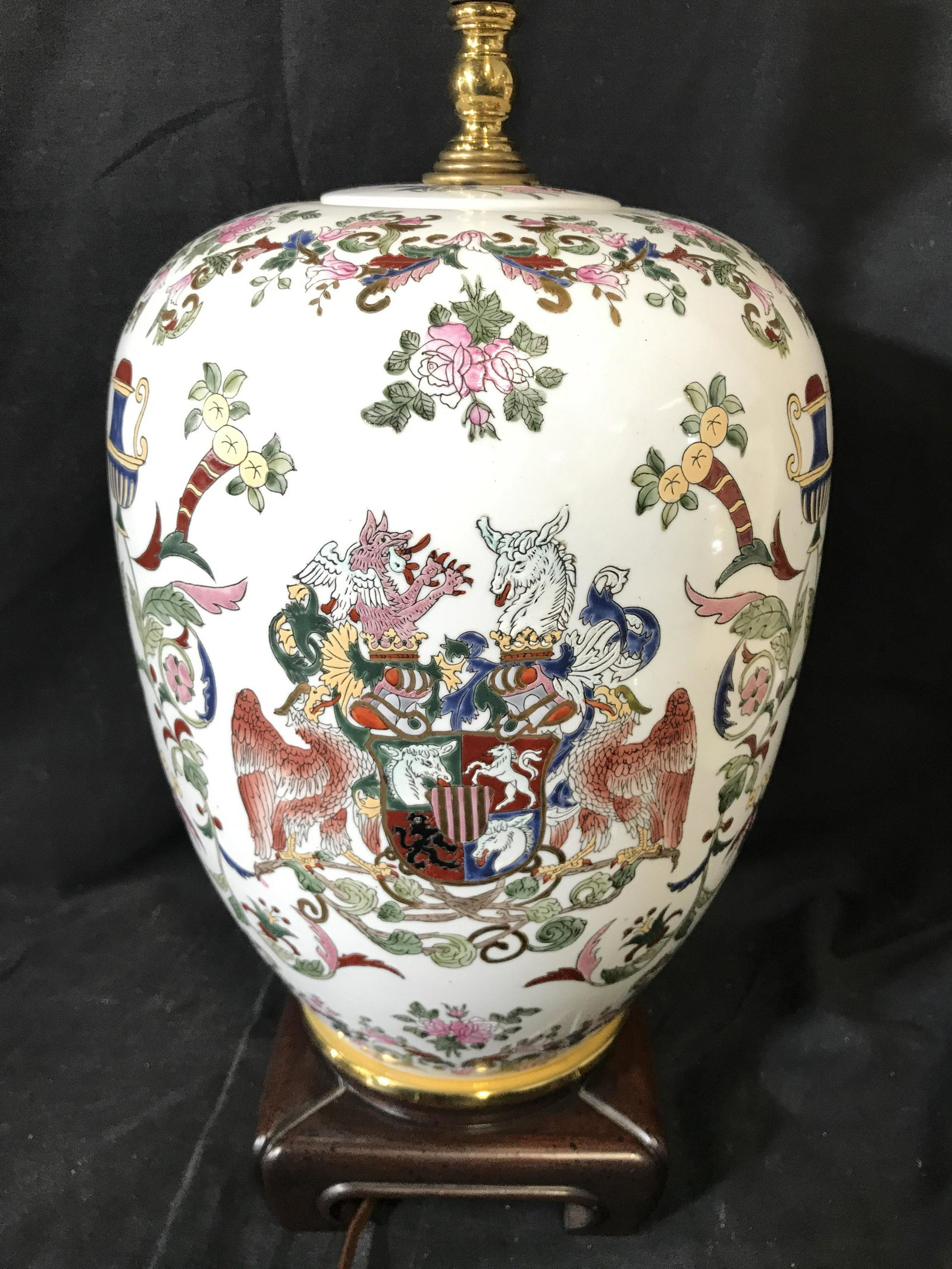 Intricately Detailed Porcelain Chinoiserie Lamp: Lamp is porcelain. Piece appears to be vintage. Lamp contains multi toned floral leaf & vine detail in addition to depictions of Decorative coat of arms & mythical animal. Piece measures approximately