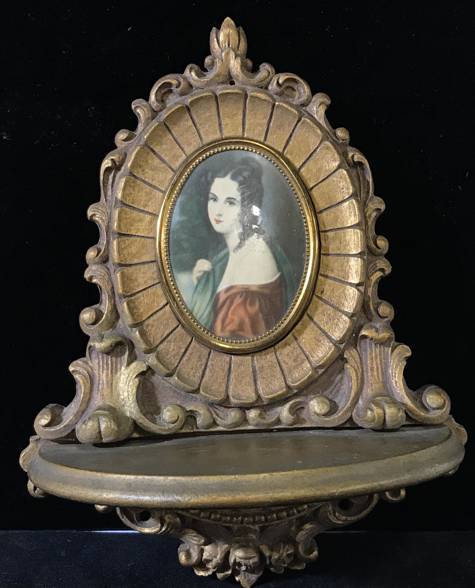 Vintage Print Medallion Wall Shelf Decor: Vintage carved wood decor, wall mount decor. Medallion is a print set beneath plastic. Wood is gold toned. Measures approx 8 inches H, and 6.25 inches W. Wear is consistent with age. Wall decor, shelv