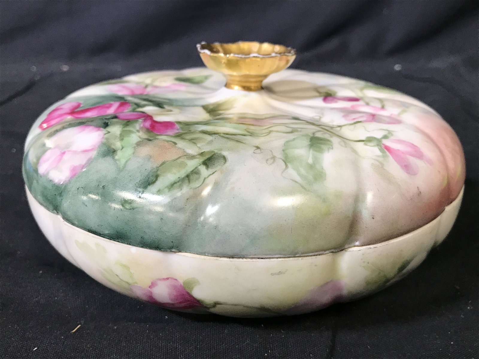 Vintage Signed D & Co Porcelain Trinket Box: Signed in floral art. Underside of piece is marked D & CO. Trinket box is porcelain. Piece has multi toned floral and leaf detail. Trinket box includes lid with gold toned handle. Piece measures appro