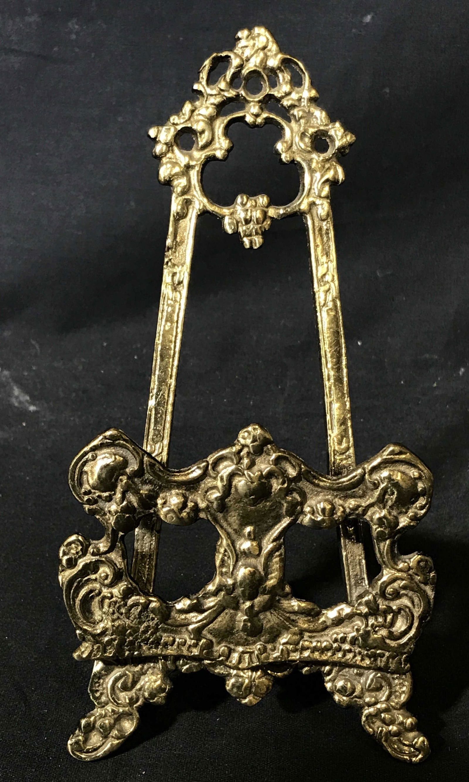 Brass Decorative Display Easel: Brass Easel, vegetal designs throughout, no apparent signatures or stamps, measures 8 inches tall and 4 inches wide, has a kick stand to the back and adjustable shelf to the front, Brass aisle, aisle,