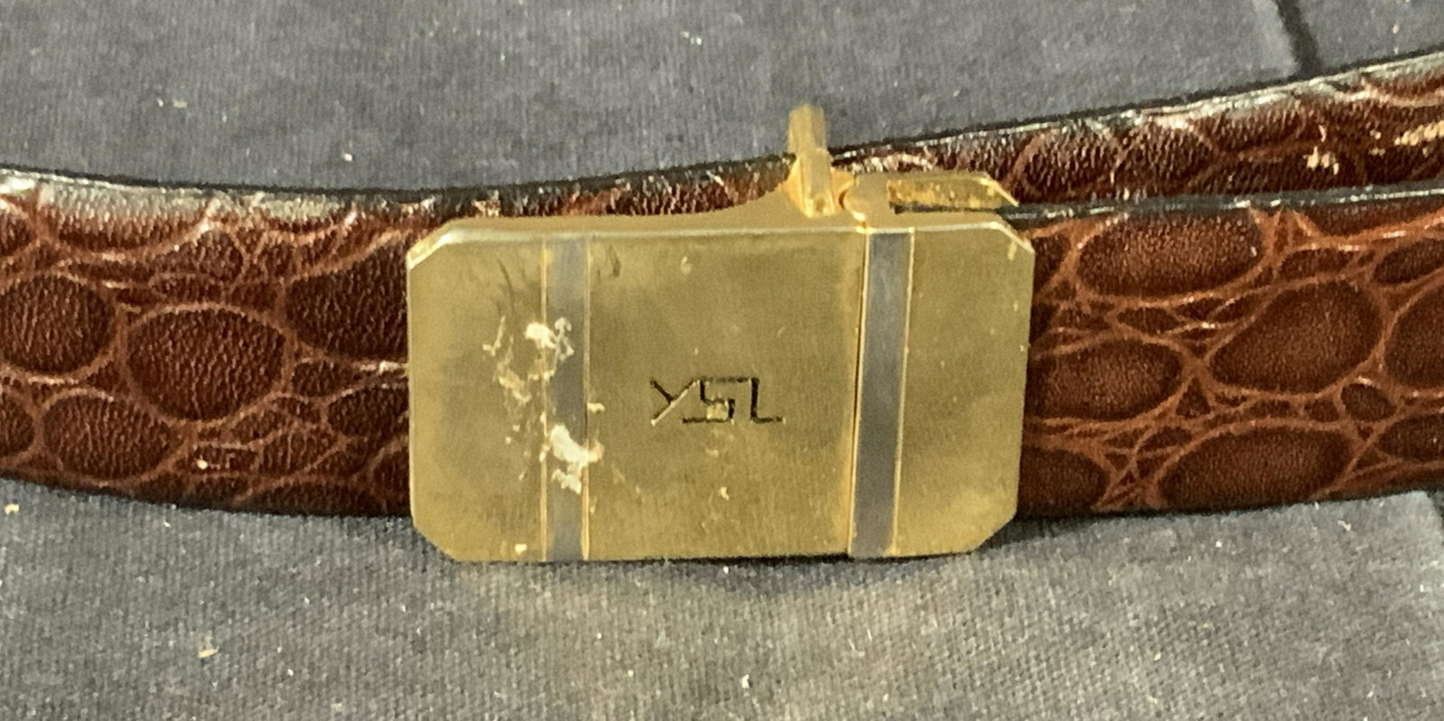 Vintage YSL Belt: Vintage leather belt by YSL with a reptile pattern pressed into the leather belt, the gold colored metal closure is adjustable for many sizes, the fastener is simple gold colored metal and the logo is