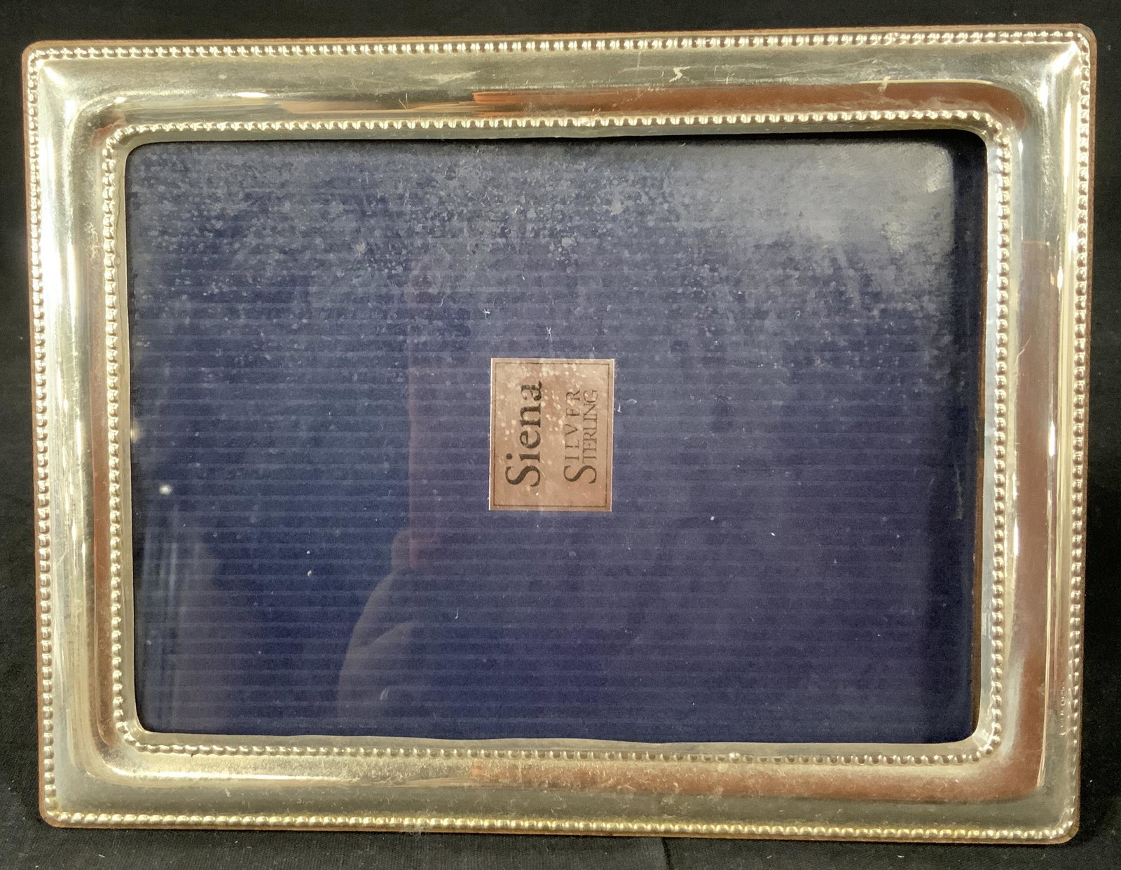 Siena Silver Picture Frame: Siena silver picture frame with varnished wood to reverse, inscription reads ‘1083 AR 925’, insert reads ‘Siena Silver Sterling’, repousse detailing on frame, sliding mechanism to open frame, 