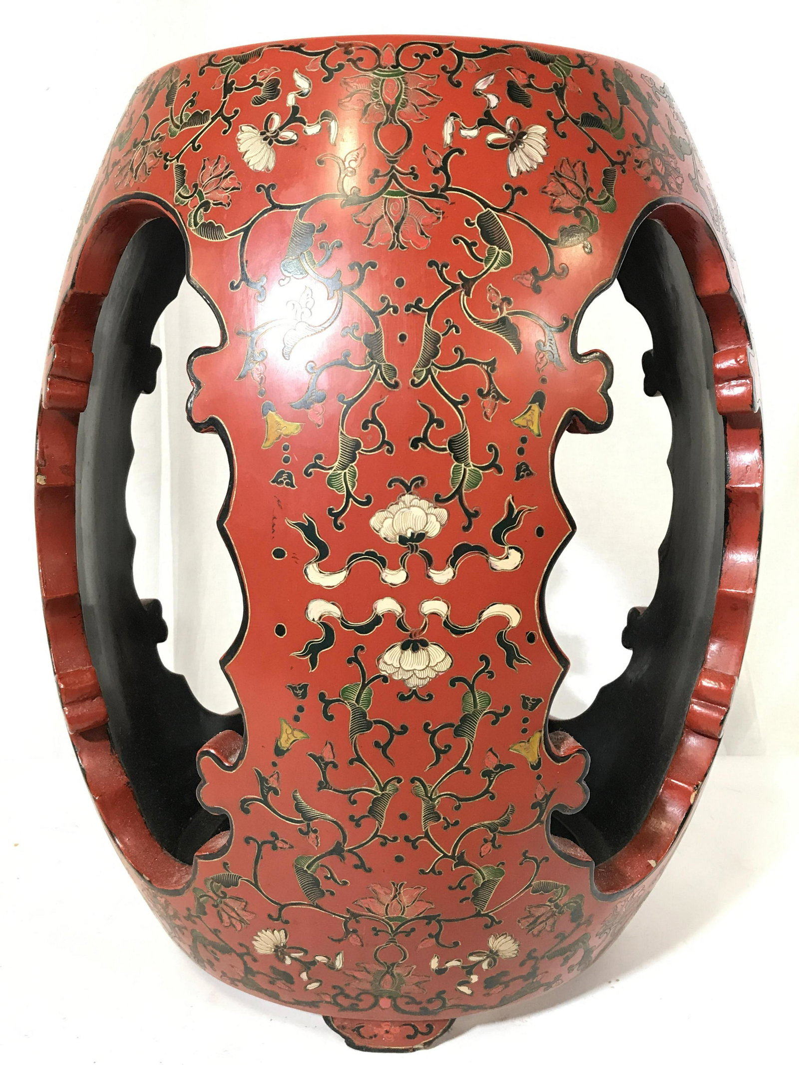 Asian Lacquered Wooden Garden Stool: Garden stool is Wooden & lacquered. Piece is red toned with multi toned floral vine and leaf detail. stool has 3 negative space areas. Stool has 4 feet each. Garden stool, Asian stool, Asian garden st