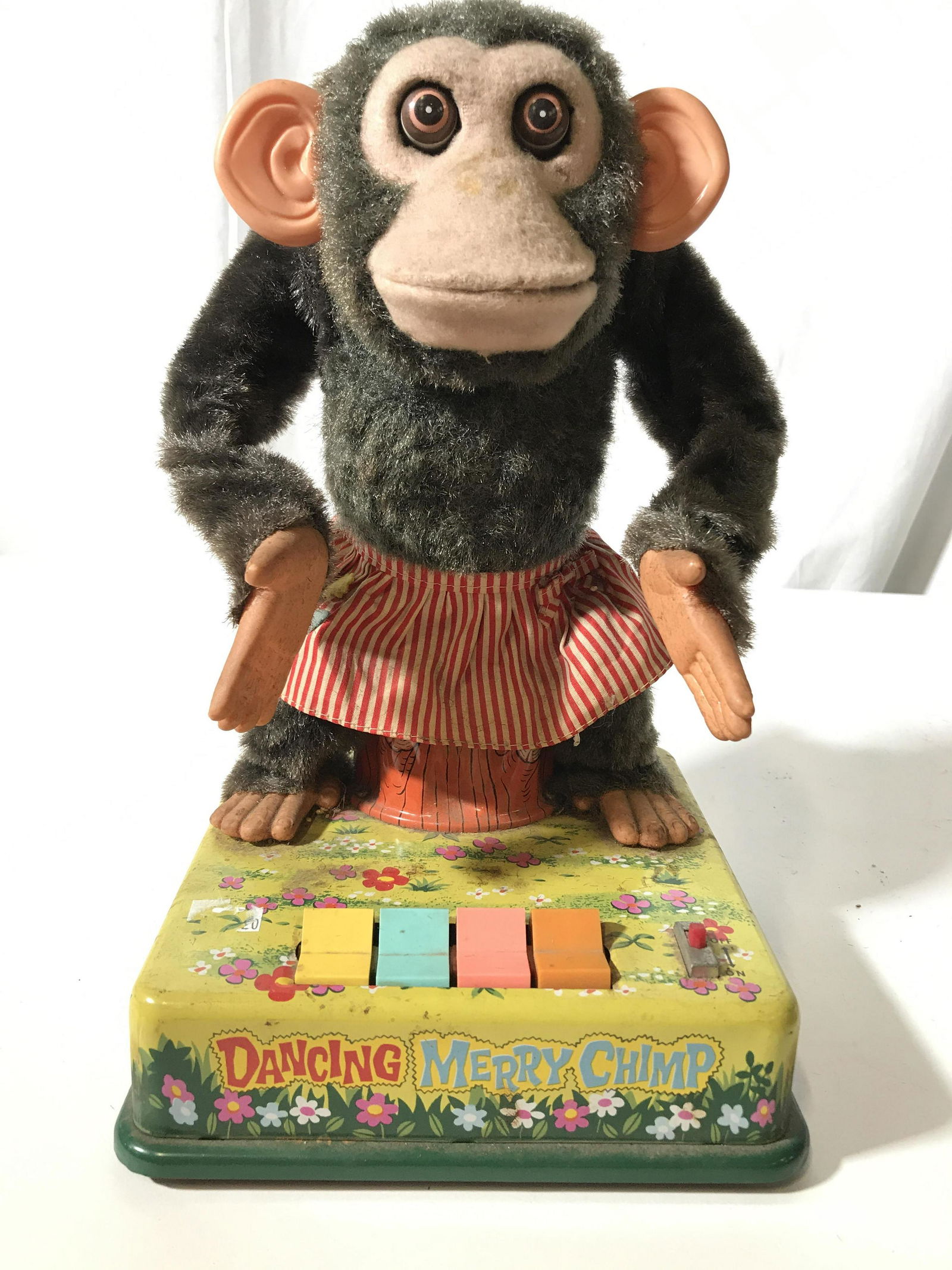 Vintage Dancing Merry Chimp Metal Toy: Underside reads made in a Japan, trade mark C K, , painted metal made, plush fabric and metal monkey toy, four buttons, one for clapping hands, wiggling ears, nodding head, and moving eyes, not tested