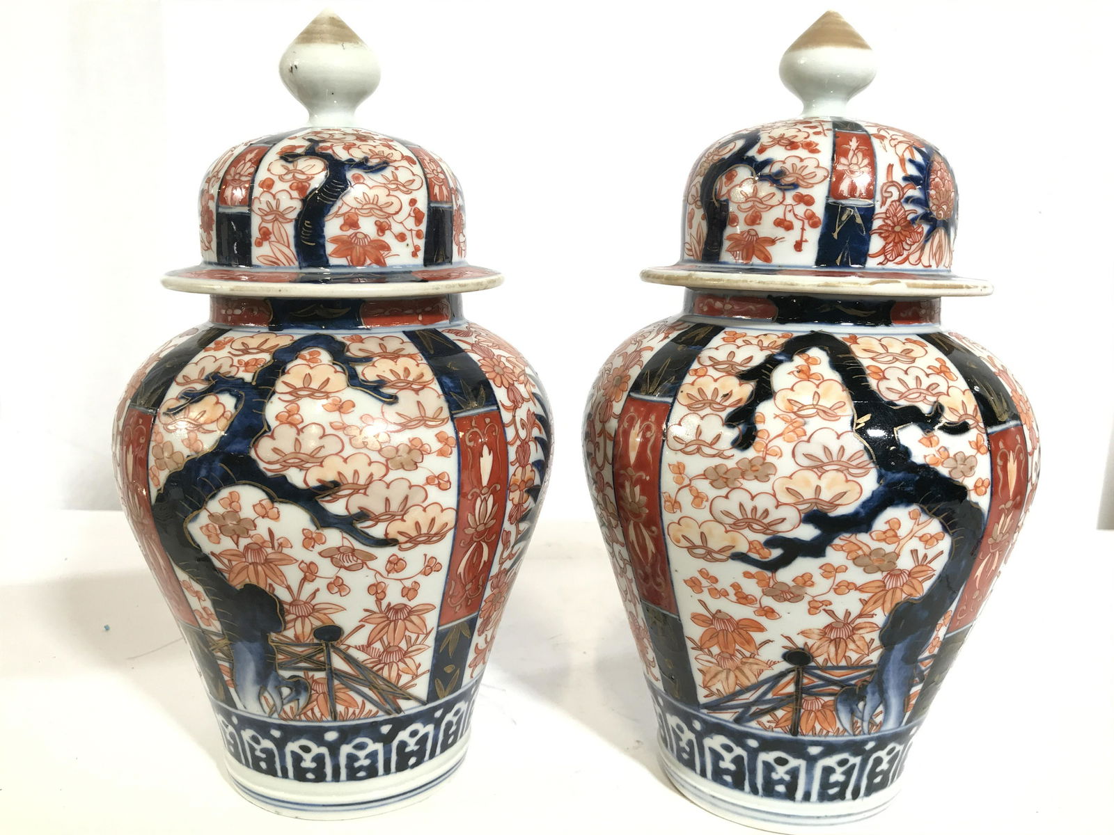 Pair Vintage Hand Painted Imari Ginger Jars: Lot includes 2 ginger jars. Each are vintage possibly antique. Jars have intricate multi toned floral, leaf, tree & geometric detail. Each piece includes lid. 7 1/2 in without lid, 11 in with lid. 6 i