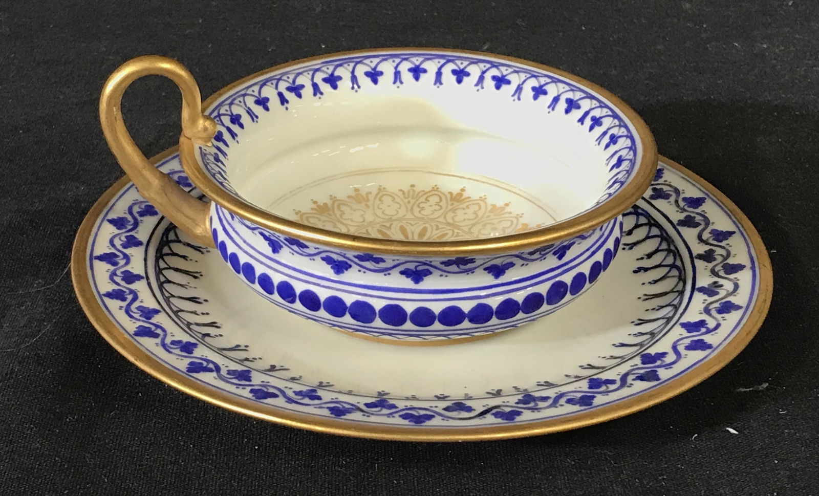 DRESDEN Tea Cup & Saucer: Vintage, possibly antique, hand painted, tea cup and saucer. The hand and rim of the cup are colored with gilt paint, the lip and center of the saucer are colored in gilt paint as well. Repeating roya