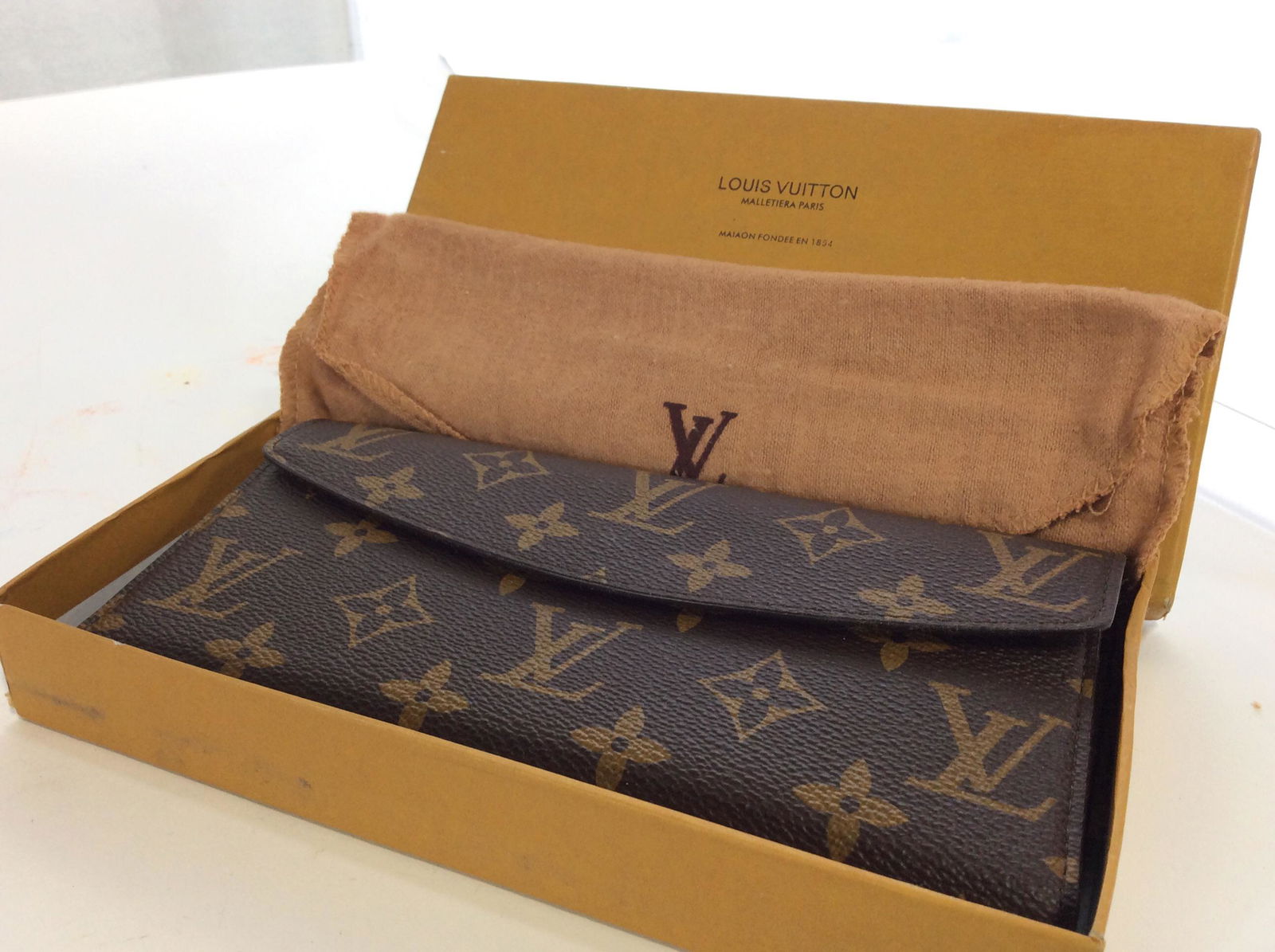 LOUIS VUITTON Billfold Wallet, Orig. Box + Duster: Signature Louis Vuitton Wall, Brown with Monogram in gold. Appears never used. Vintage. Comes with original duster cloth and original box. Wallet 7.5 x 4 in. Fold over flap with snap closure. Includes