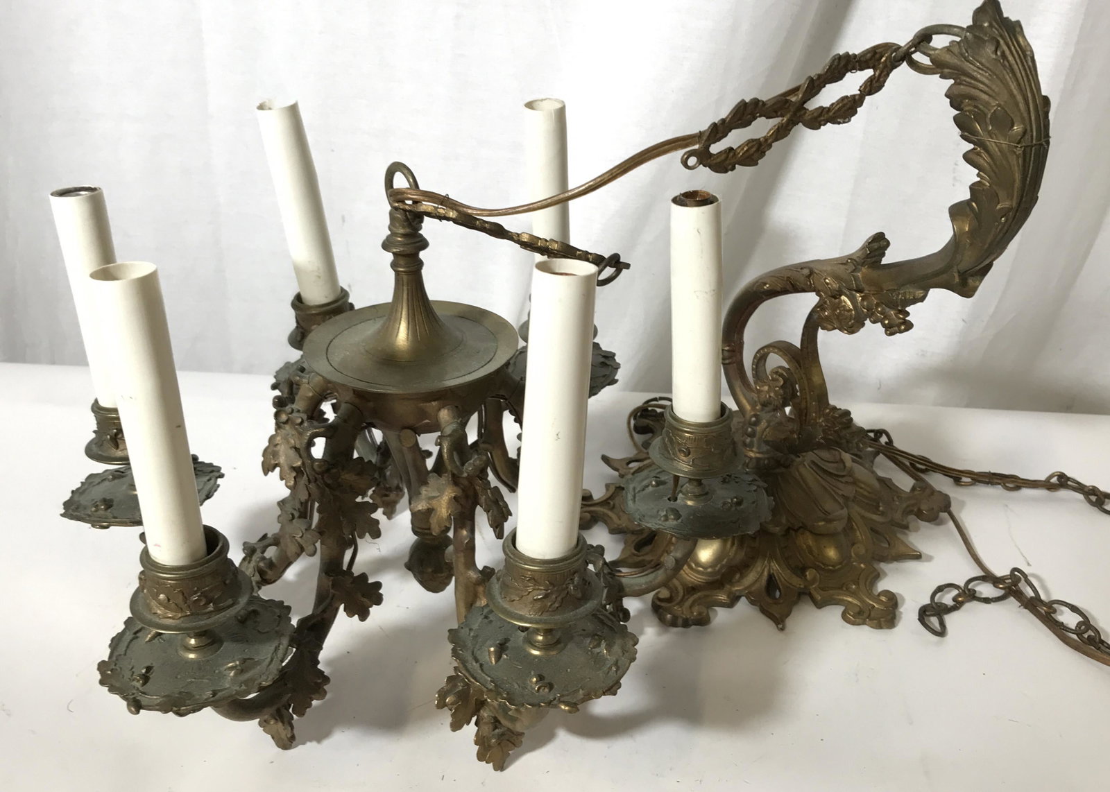 Antique Brass 6 Arm Filigree Motif Chandelier: Vintage, possibly antique, chandelier. Crafted from brass. Wear is consistent with age and use. Measures approx 29 inches H, when suspended, and 13 inches W. Each candle arm is crafted to resemble a b
