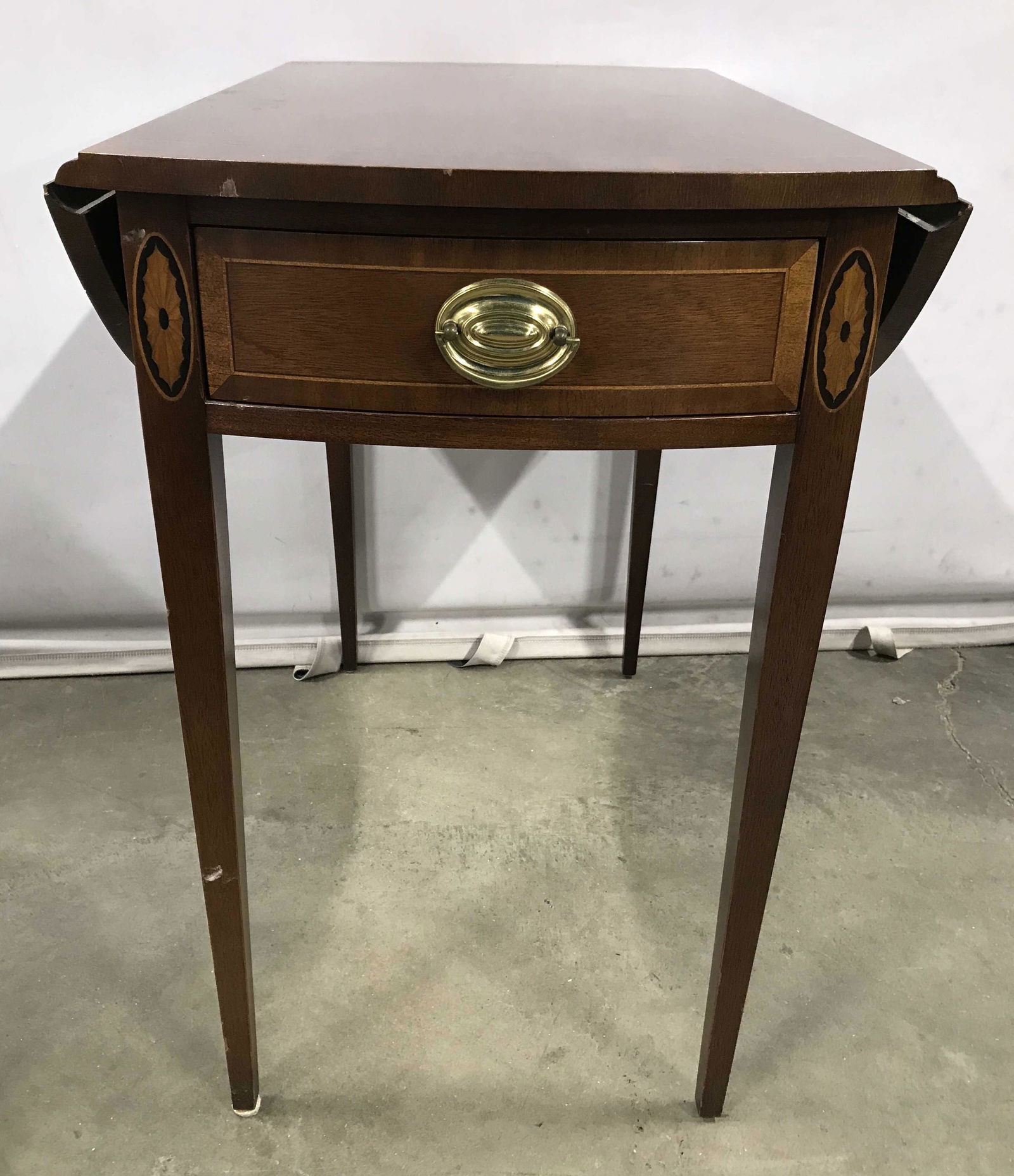 Vintage COUNCILL Wooden Drop Leaf Table W Drawer: Interior of drawer has tag which reads COUNCILL. Side table has drop leaf on each side. Front of piece has drawer with gold toned brass handle. Piece measures approximately 25 inches tall and deep 29