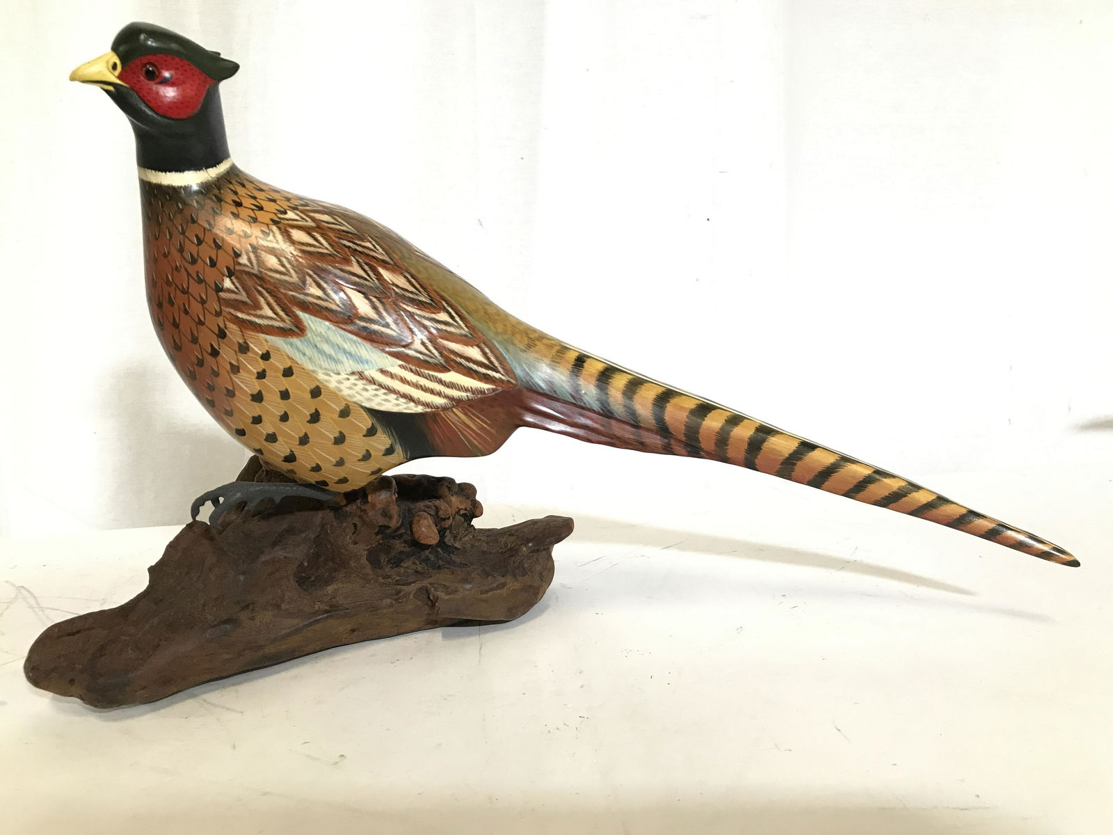 Carved Wooden Pheasant Sculpture: Pheasant sculpture is wooden. Piece appears to possibly be hand painted. Piece measures approximately 20 inches long 12.5 inches tall 8 inches wide. Pheasant sculpture, wooden pheasant, decorative phe