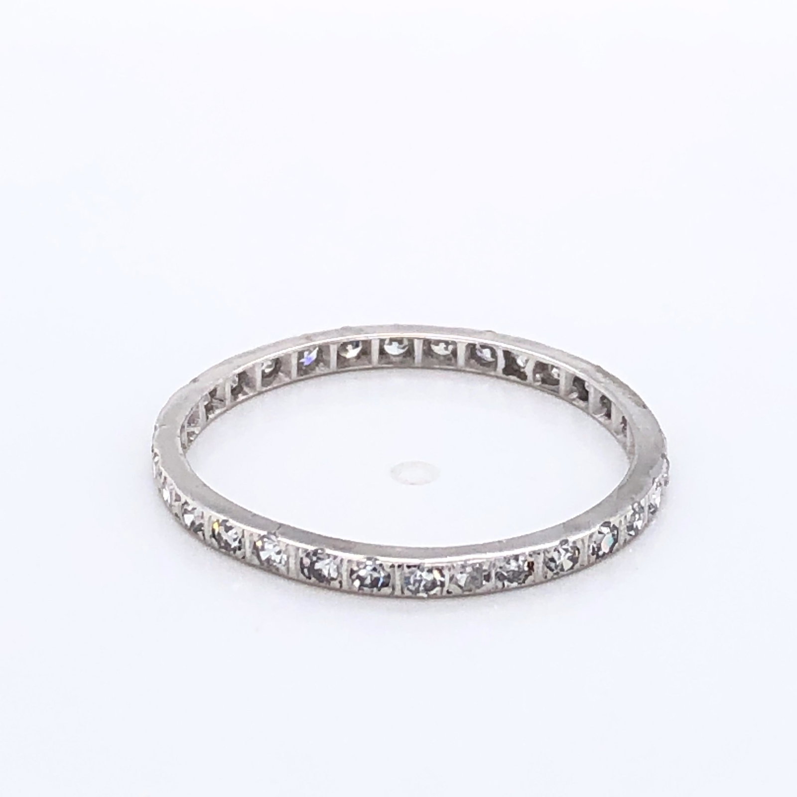 14 Karat White Gold and Diamond Eternity Band: Dainty and lovely eternity band is made of 14K white gold with diamonds surrounding it. Wear it alone for a bit of playful sparkle or stack it with other rings. Size 8