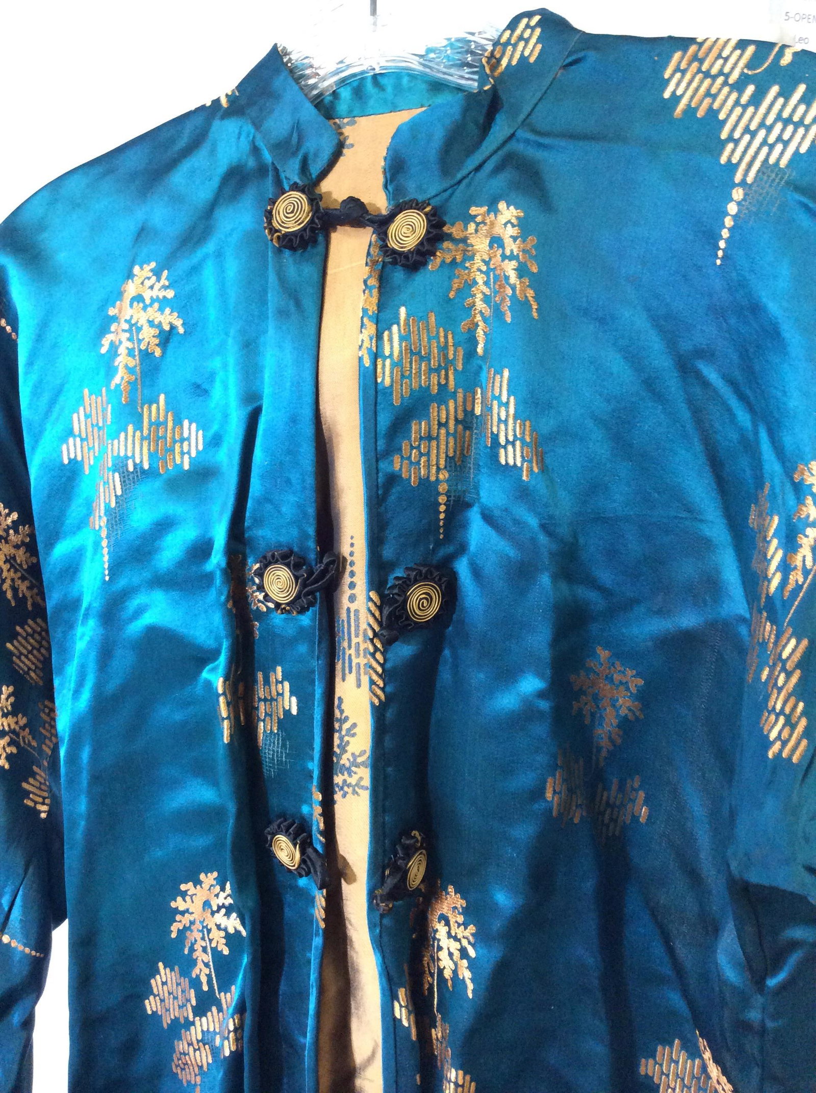Silk Asian Teal Jacket, Vintage: Teal silk with Bronze embroidered short line patter. Floral silk buttons in black outlined in bronze. Interior bronze silk. Good vintage condition. Light spotting on one cuff, punctures from exposure 