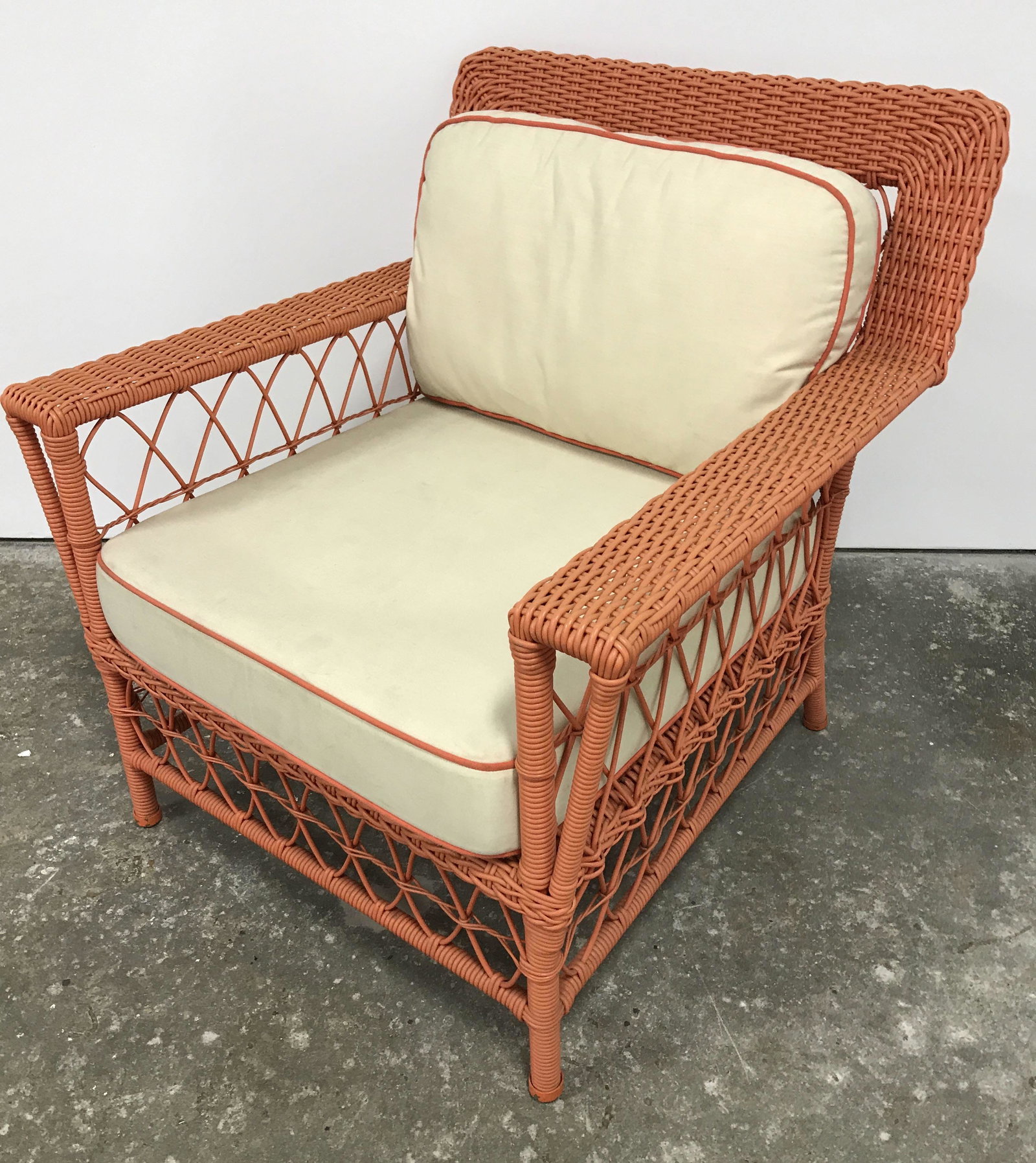Vintage Woven Peach Toned Chair: Vintage outdoor arm chair. Chair is peach toned and appears to be crafted from a composite material. The material is woven. Upholstered cushions are single welt. Measures approx 34.5 inches H, 33 inch