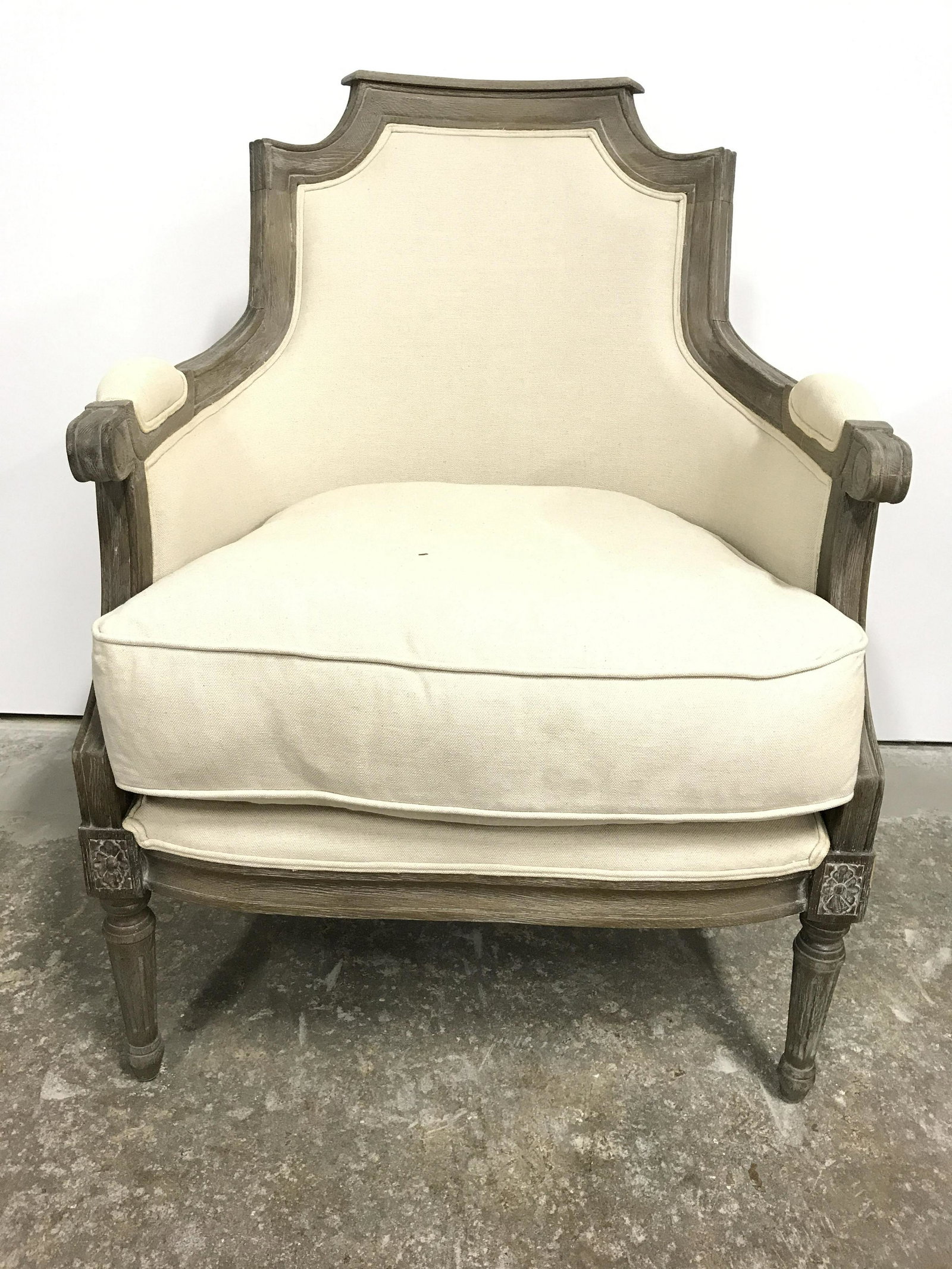 LOUIS XVI Style Bergere Chair: Bergere has slate toned carved wooden frame and cream toned upholstery. Edges of upholstery have double welting. Piece has upholstered armrests. Chair is Louis XVI style. Piece measures approximately 