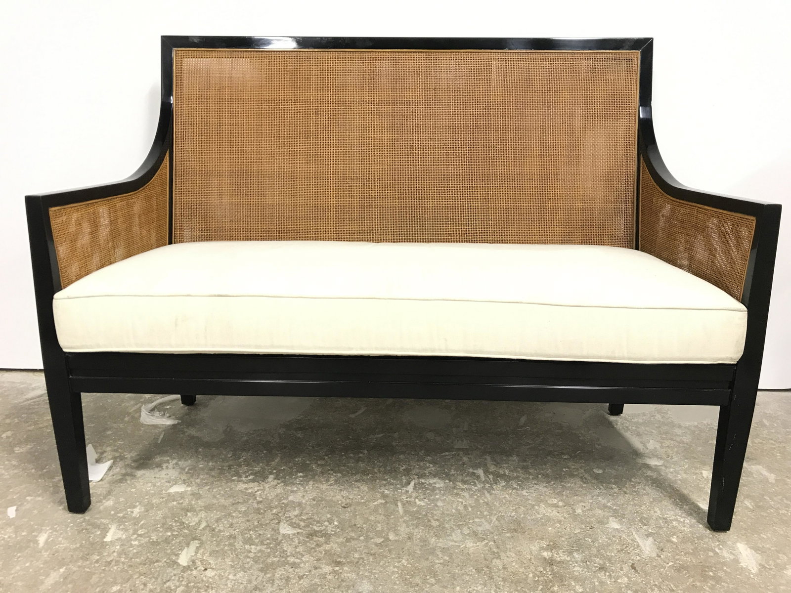 Caned Lacquered Asian Style Bench W Cushion: Bench is black toned and lacquered. Piece has double caning on backrests and armrests. Piece includes cream toned seat cushion. Piece measures approximately 54 inches long 40 inches tall 26 inches dee