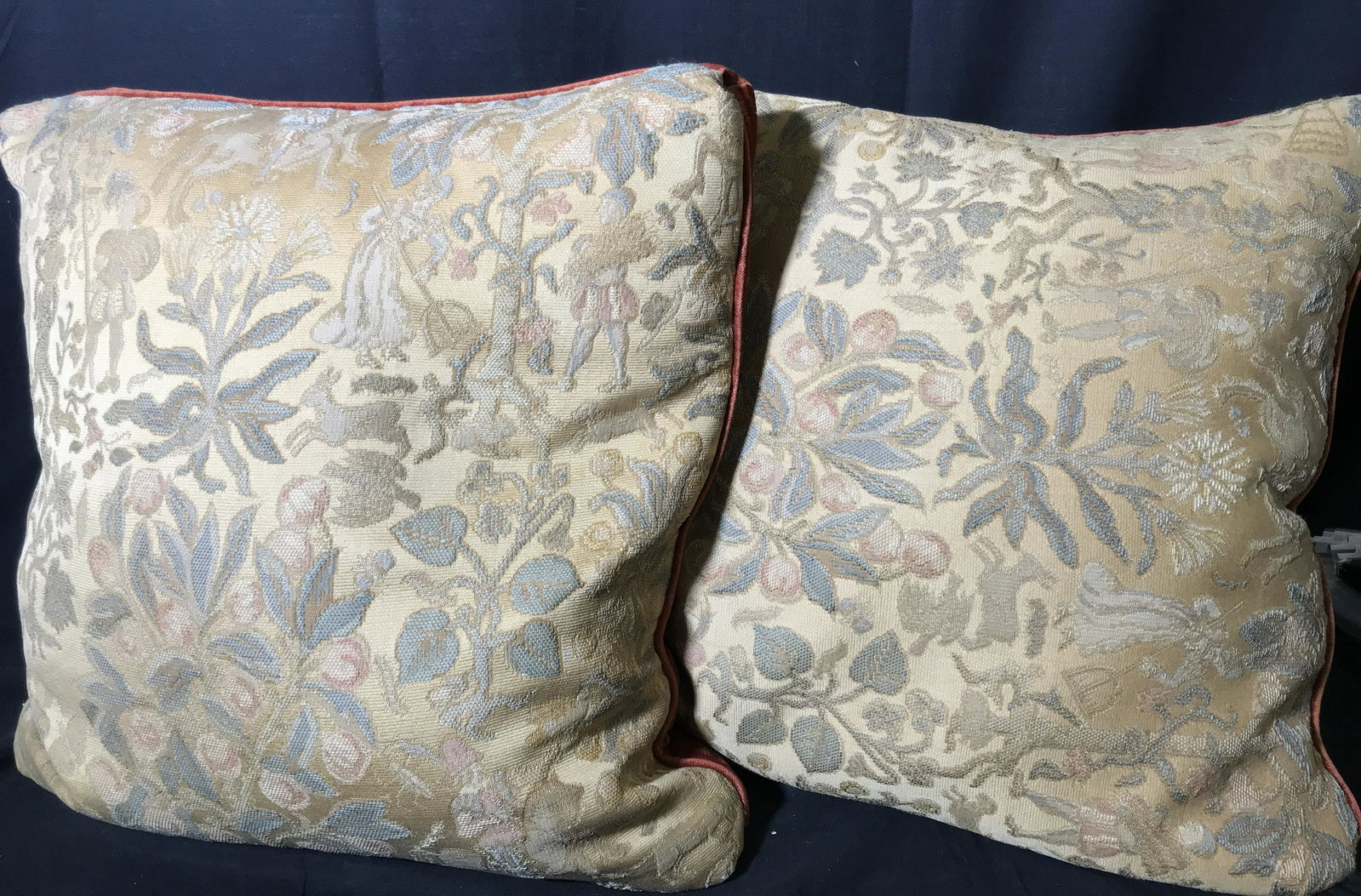 Pair Vintage Need Point Pillows: Pair vintage needle point pillow, front of both pillows displays a vegetal design with what appears to be figures working a farm, reverse has a reddish orange colored velvet material, no apparent tags