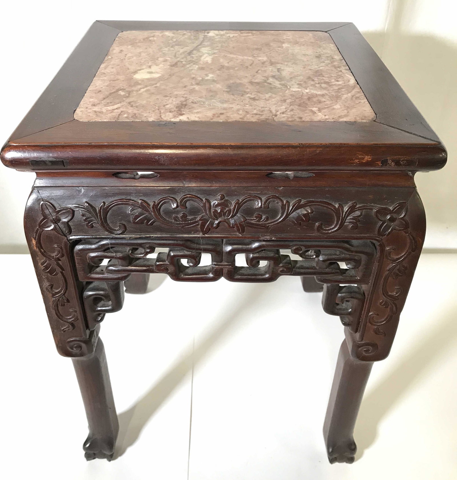 Antique Marble Top Carved Wooden Side Table: Side table appears to be antique. Piece has intricately carved wooden detail. Table top appears to be marble, possibly stone. Piece has carved floral vine and leaf detail. Piece measures approximately