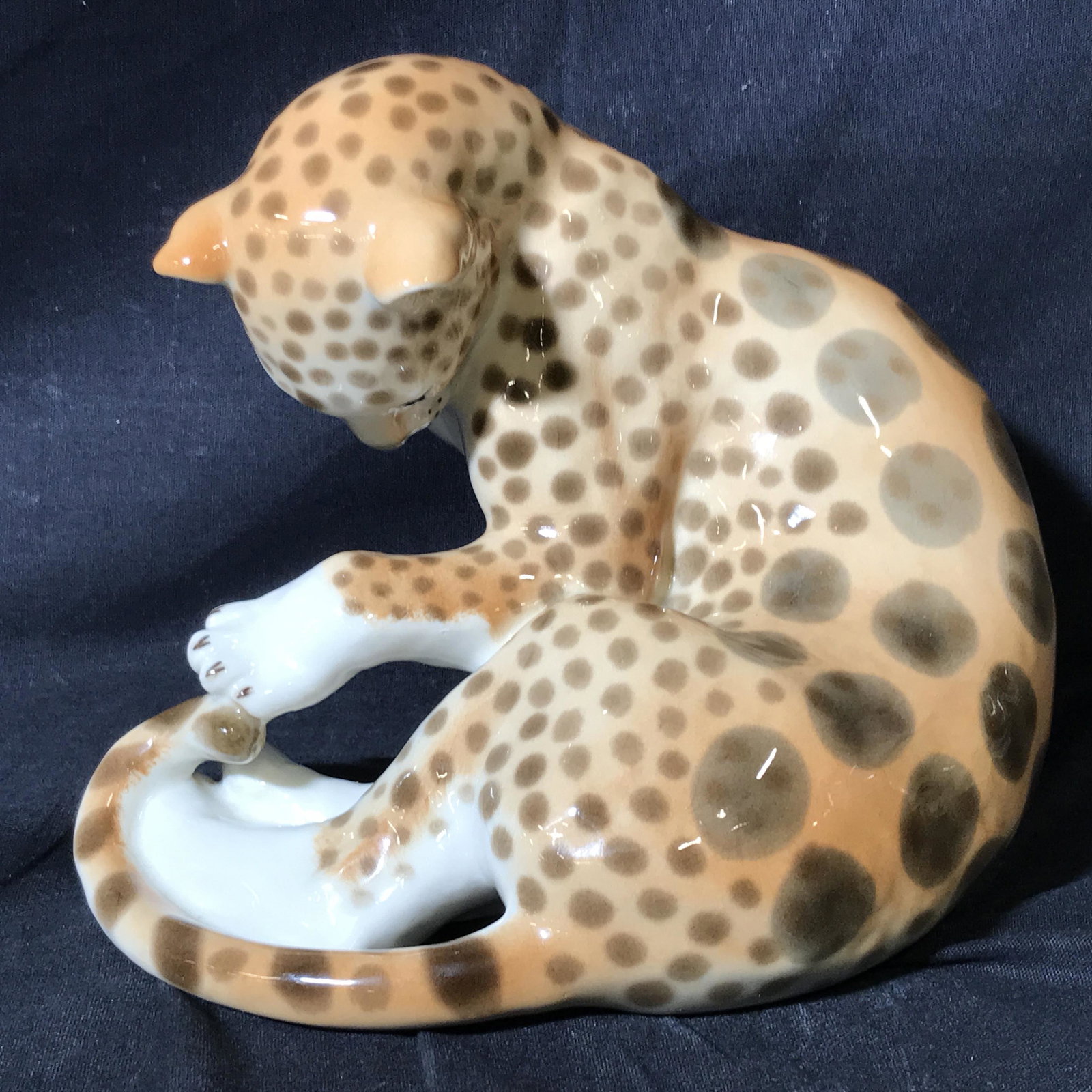 Russian Porcelain Cheetah Statue: Russian porcelain cheetah statue, stamp to underside in red reads ‘Made in USSR’, subject a seated cheetah grooming itself, hand painted, measures approximately 7 inches tall and 9 inches wide, Ru