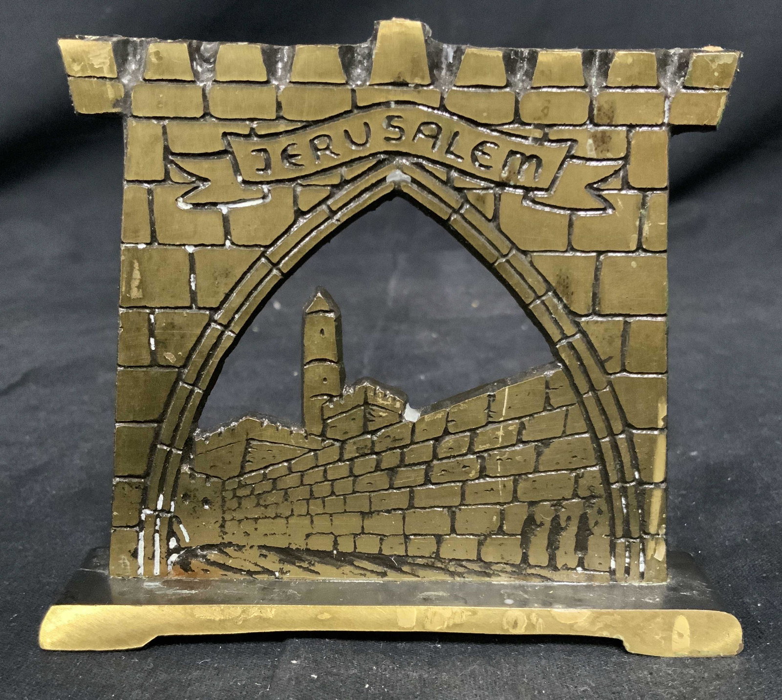 Desktop Brass Menorah, Israel: Vintage desktop menorah. Depicts three figures visiting the WESTERN WALL. MADE IN ISRAEL is engraved on the back. The piece measures approx 4 inches H, and 4.5 inches W. Wear is consistent with age an