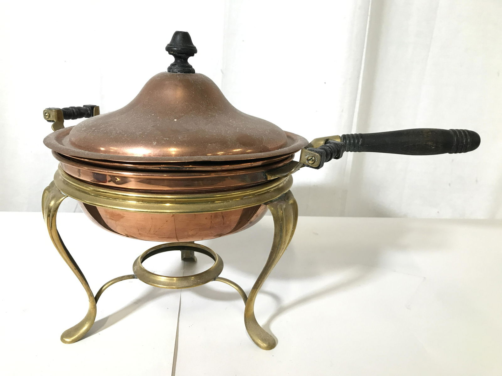 Vintage Copper Toned Fondue Pot: Pot is copper toned. Piece has gold toned metal stand with 3 gold toned feet. Piece includes lid, upper pot area has handle. Lower pot area has handle on each side. Piece when put together measures ap