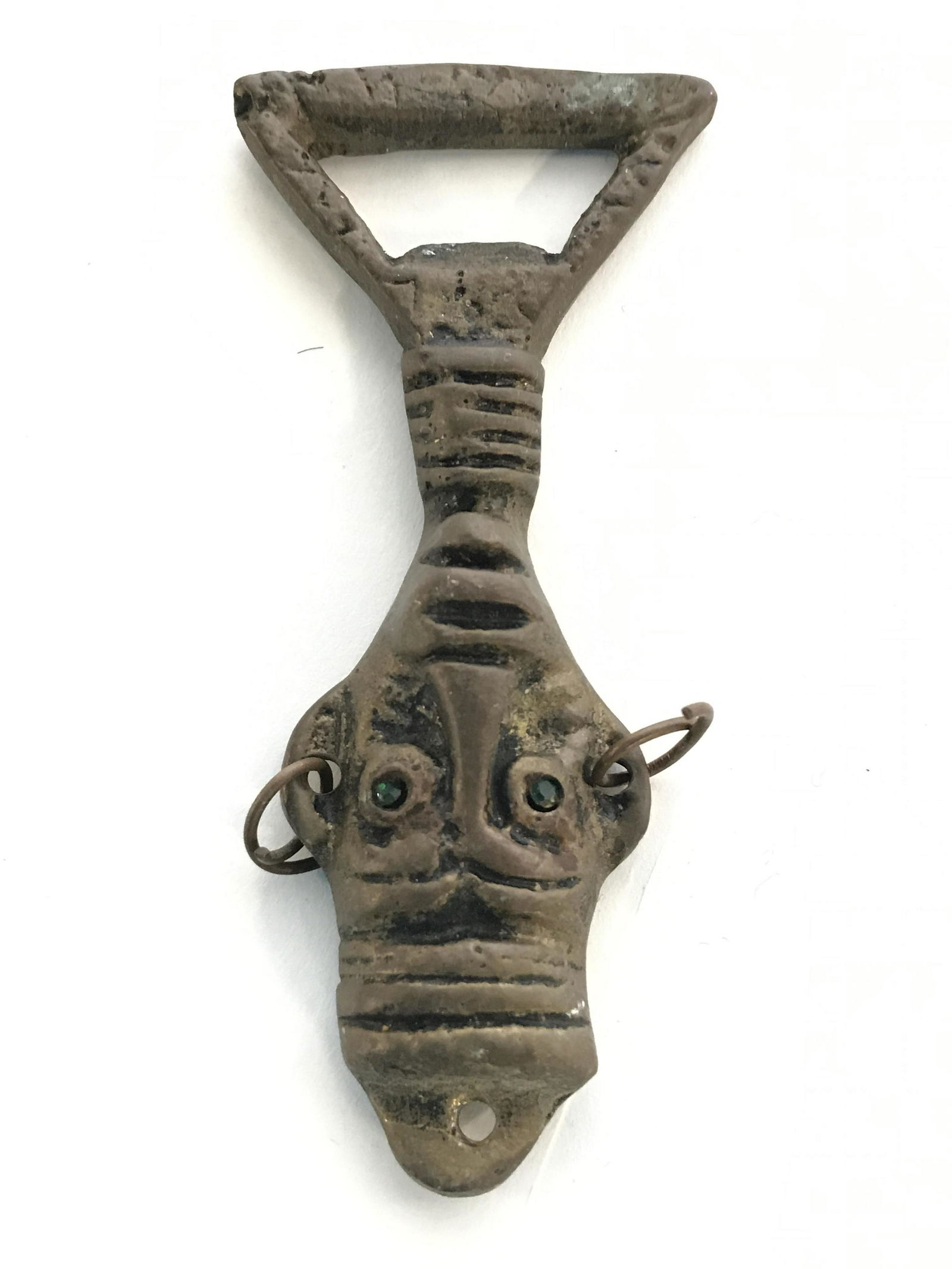 Vintage Tribal Style Bottle Opener: Bottle opener is vintage. Contains tribal style with head Figural. Piece appears to have green toned rhinestone detail. Piece measures approximately 4 inches long 1.5 inches wide. Bottle opener, vinta