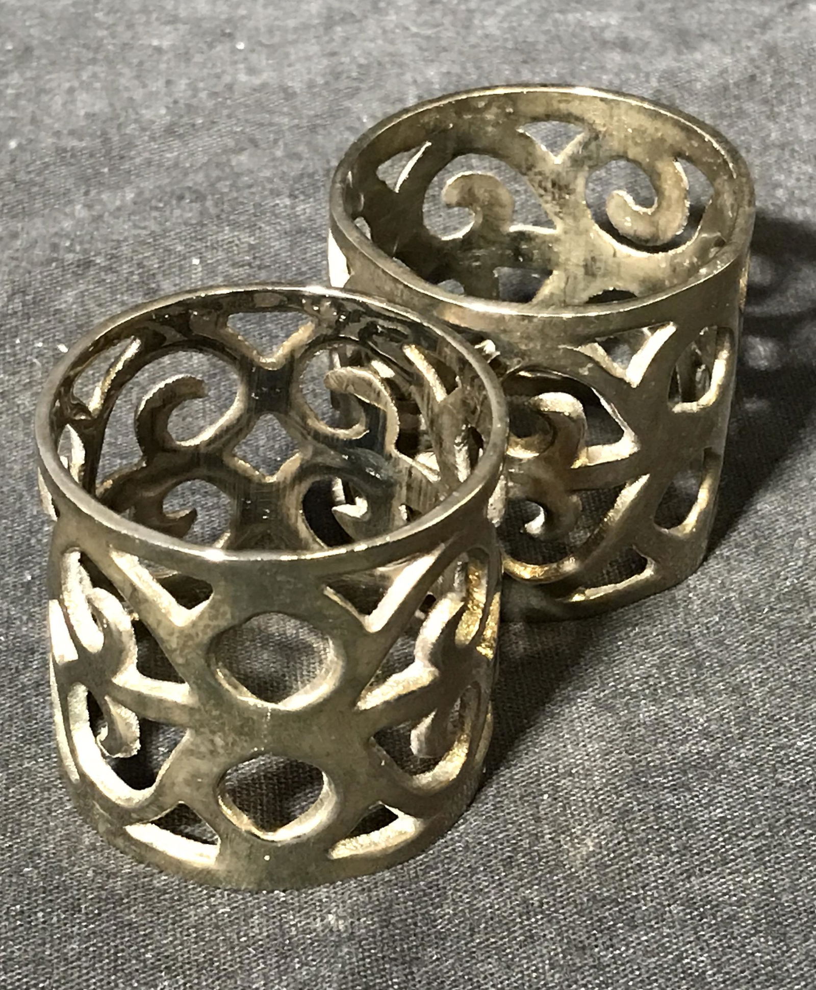 Pair Metal Napkin Rings: Pair of metal napkin rings, made of a silver toned metal, decorated with vine designs, both have wear to surface, both measures 1.5 inches tall and 1.75 inches in diameter, Pair, napkin rings, decorat