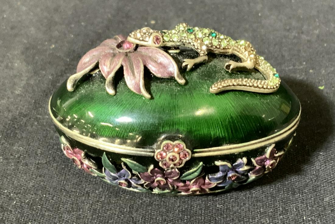 Petit Tresor Enameled Pill Box: Petit Tresor trinket box, label affixed to base reads ‘Petit Tresor’, box with floral designs and lizard with multicolored inlaid stones, green enamel to exterior and pearlescent enamel to interio