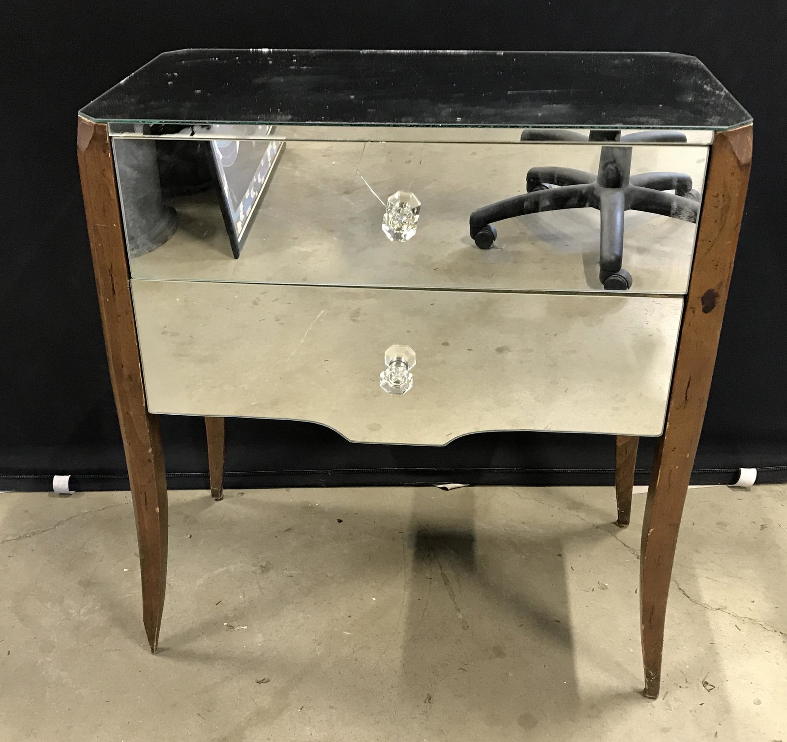 Vintage Mirrored Side Table: Vintage side table, surfaces of table are mirrored. Drawer handles are cut glass, legs are wood. Measures approx 27.25 inches H, 25 inches W, 13.5 inches deep. Wear is consistent with age and use, fro