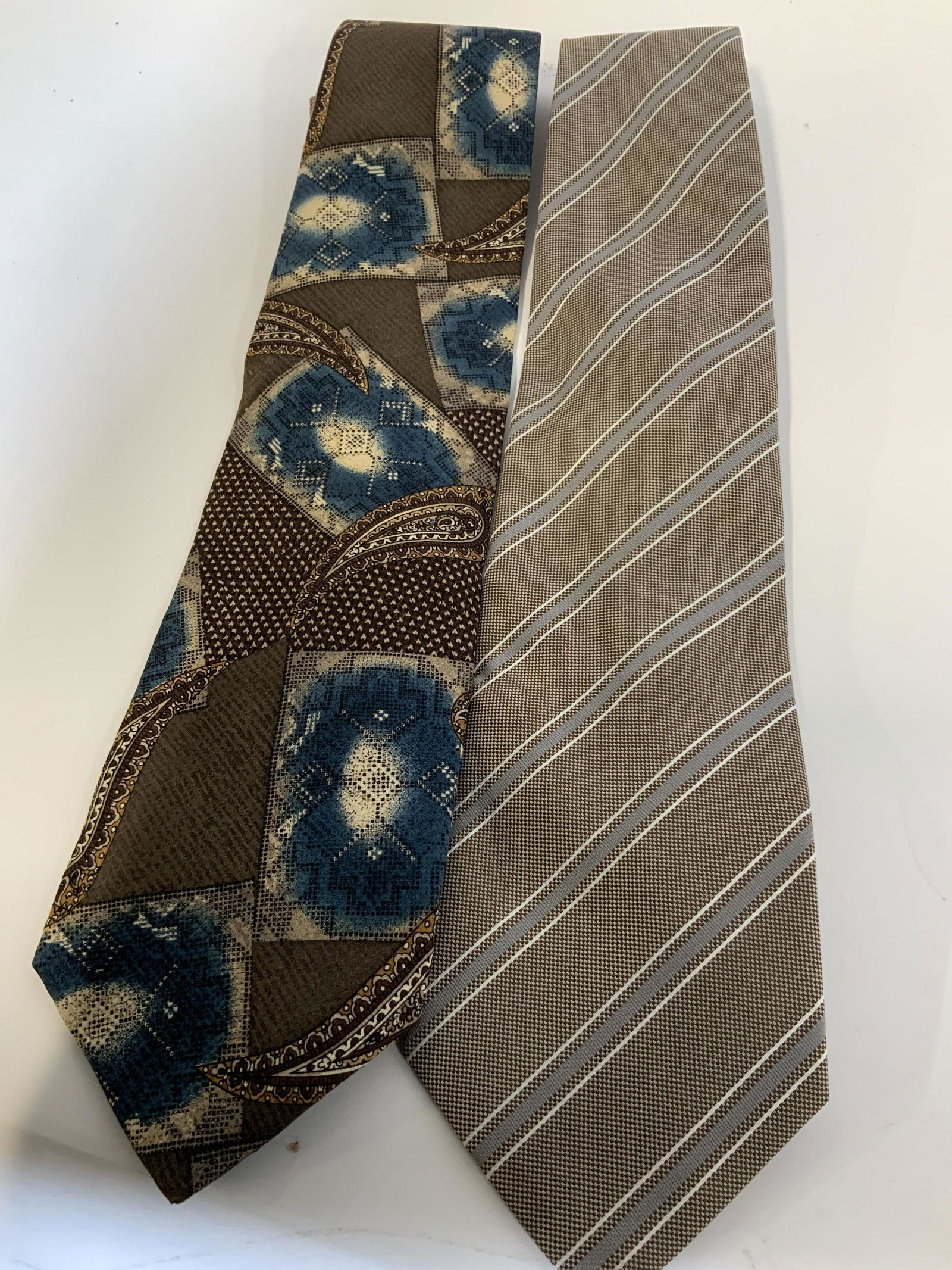 Lot 2 Vintage Grey and Blue Ties: Set of two vintage ties both in Grey and Blue color ways, both ties are highly patterned, Brand labels reads Pierre Balmain 100% Italian silk. which has a mixed, patchwork And paisley style look, the