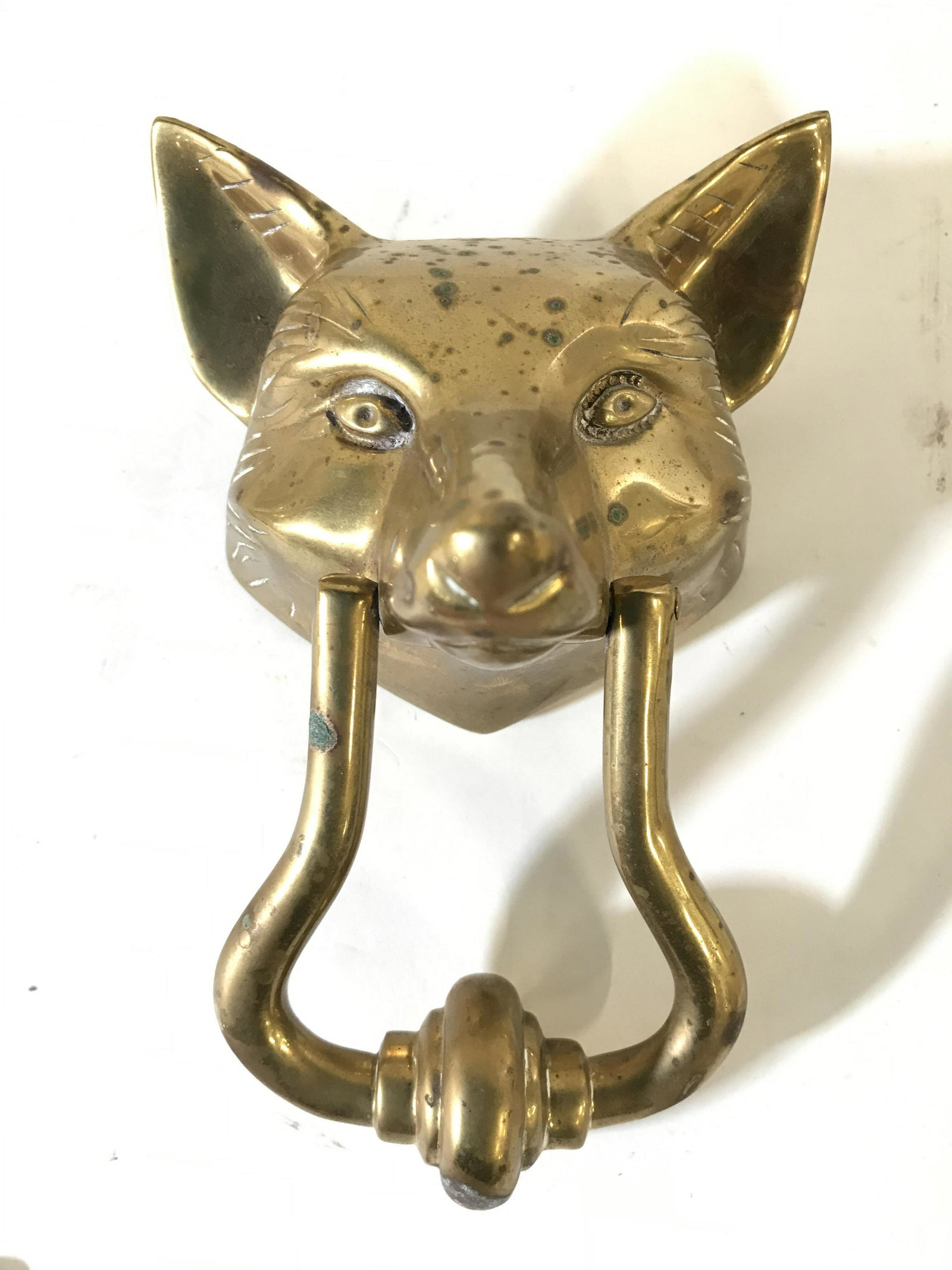 Vintage Gold Toned Solid Brass Fox Door Knocker: Door knocker is gold toned & brass. Piece is vintage possibly antique. Knocker has shape which resembles fox head. Piece measures approximately 6.5 inches tall 5 inches wide 4 inches deep. Door knocke