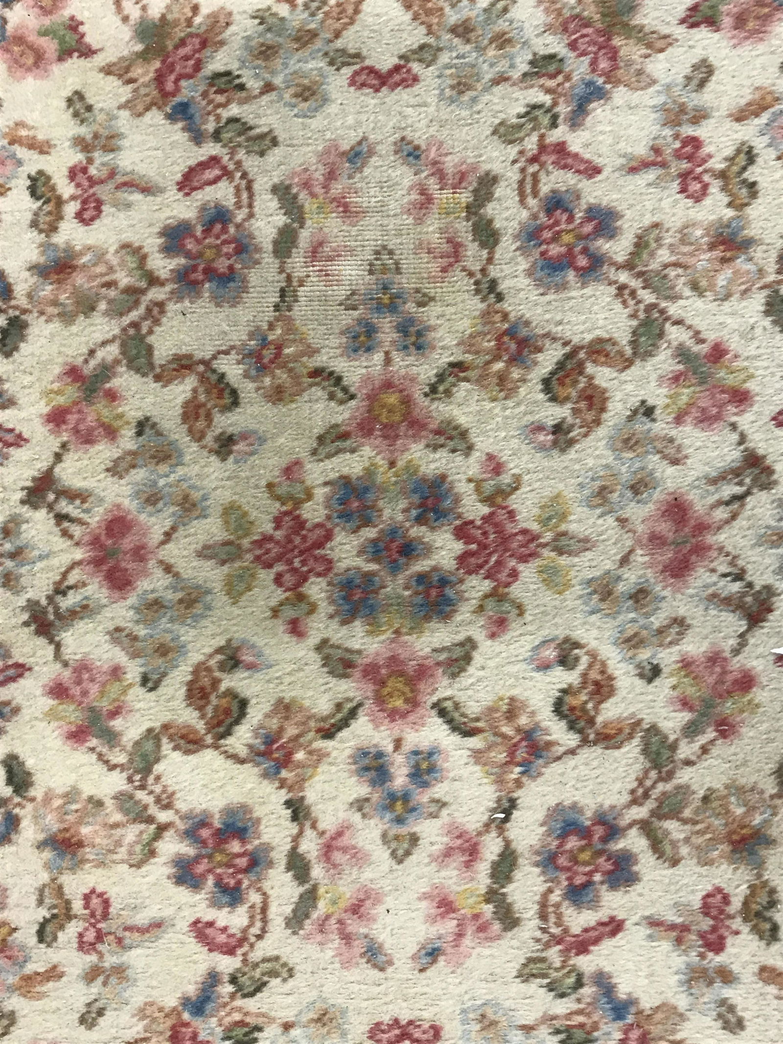 Vintage KARASTAN Wool Area Rug: Vintage, possibly antique, wool rug. Rug contains multi toned floral vine & leaf detail. Carpet is fringed. Piece measures approximately 62 inches long 34 inches W. Label on underside reads as: KARAST