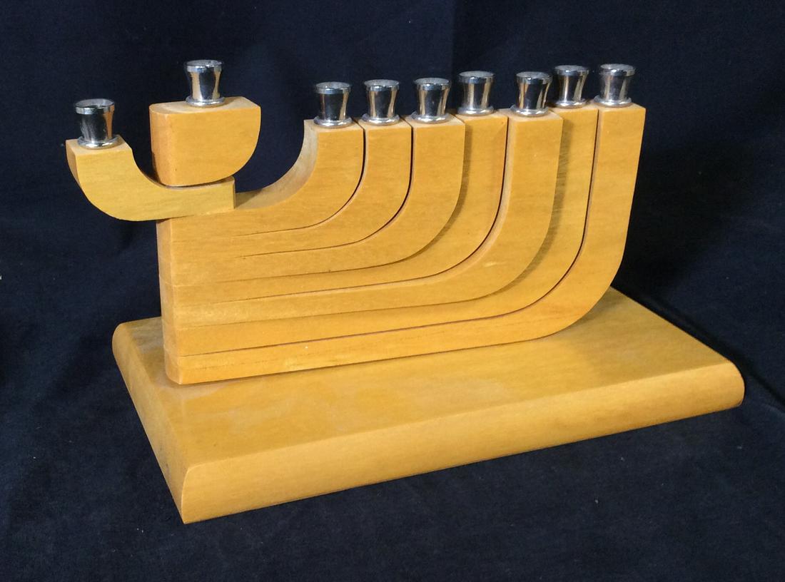 Collectible Handcrafted Wood Menorah, Signed: Signed Artist possibly reads ‘Jim Arkon’ , hand written in marker. Light wood, possibly maple wood. Menorah is like a puzzle, stacked together. Each night a light is lit, swing over the arm. Measu